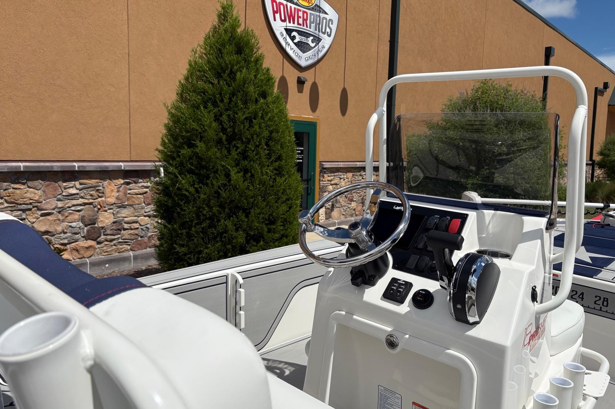 2026 Mako 18 Pro Skiff Patriot Edition boat console with steering wheel and controls.