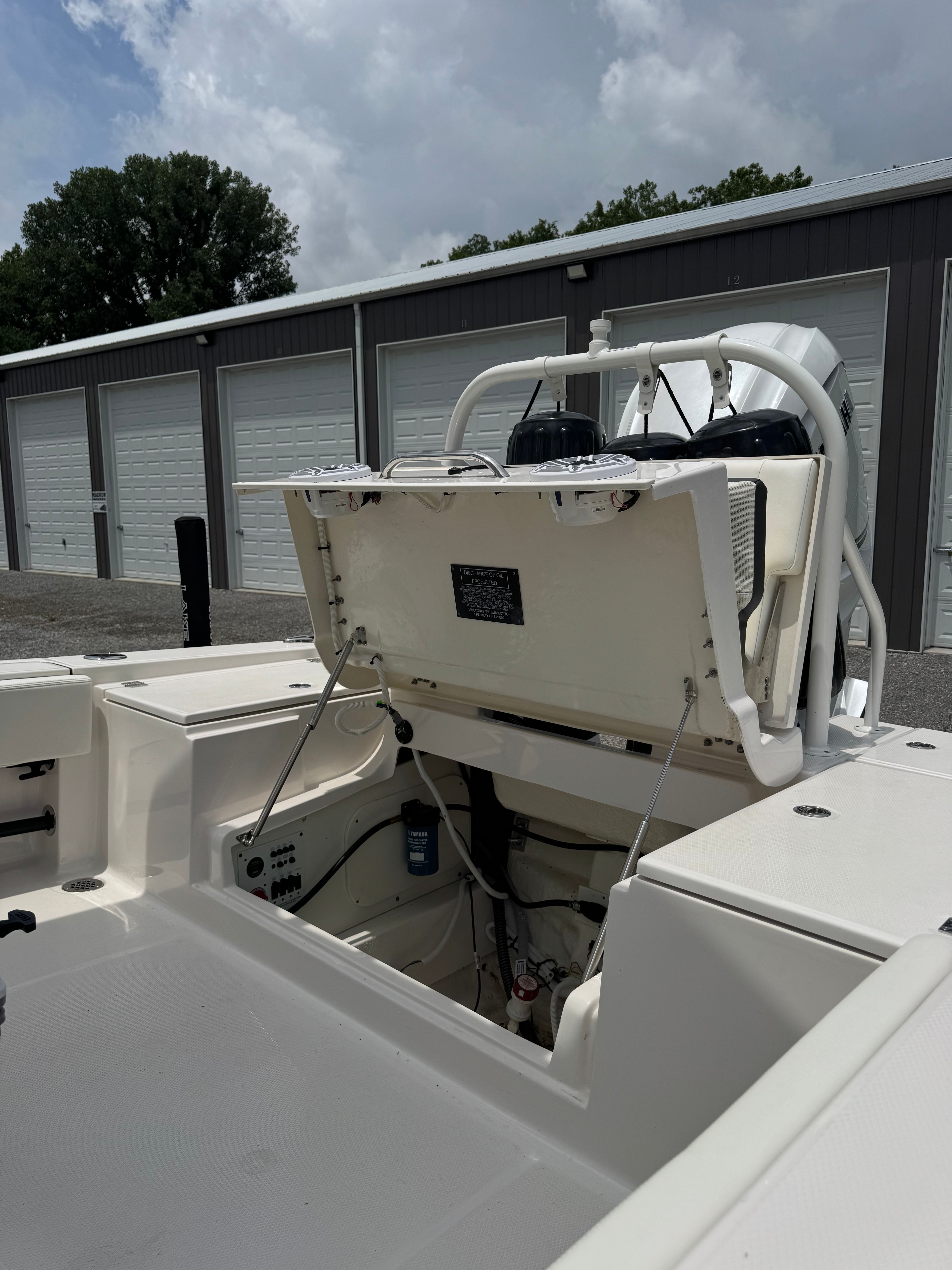 The image shows the open stern of a 2023 Robalo 266 Cayman boat in a storage area.