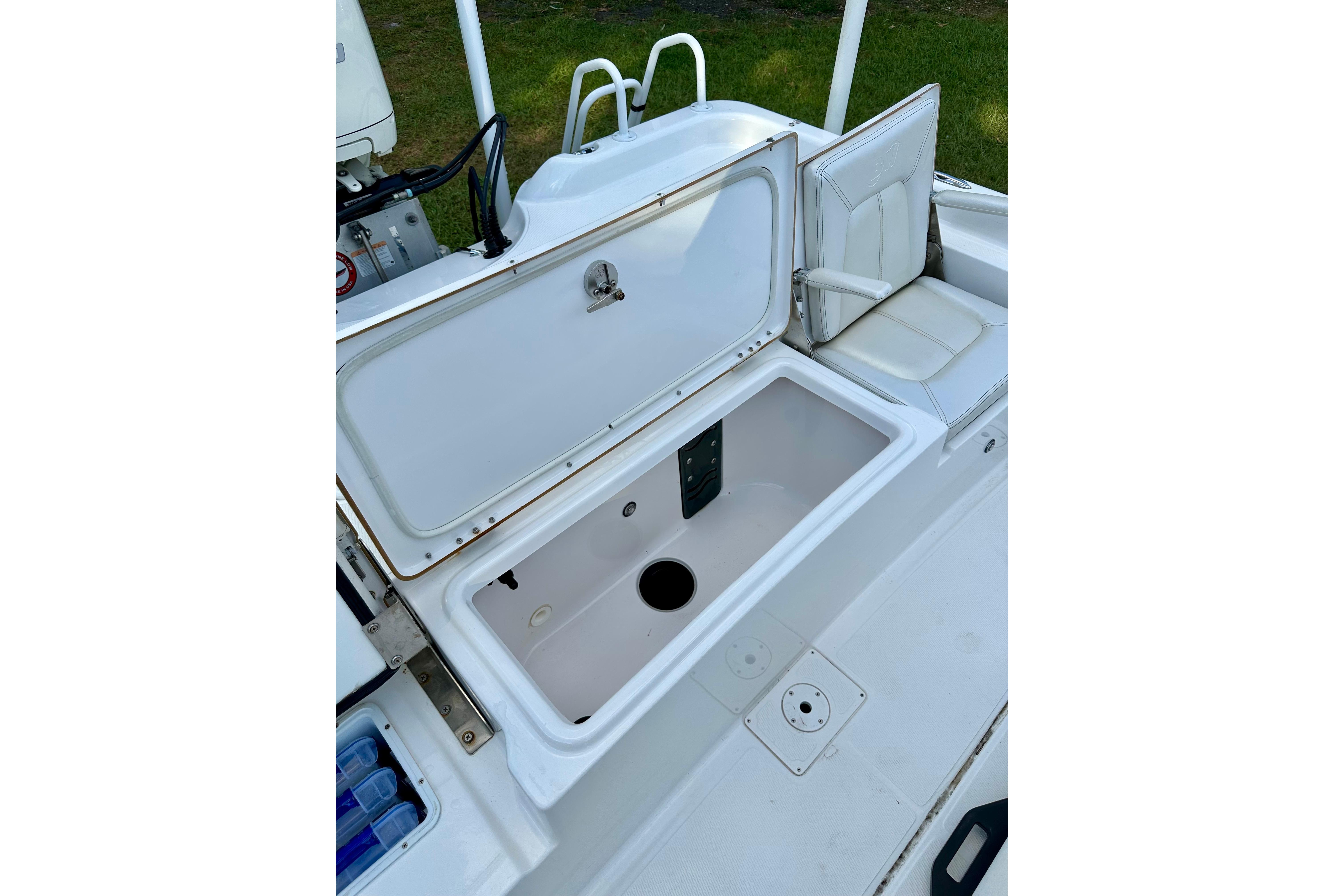 Open storage compartment on 2017 Blue Wave 2400 PureBay boat, featuring white seating and clean design.