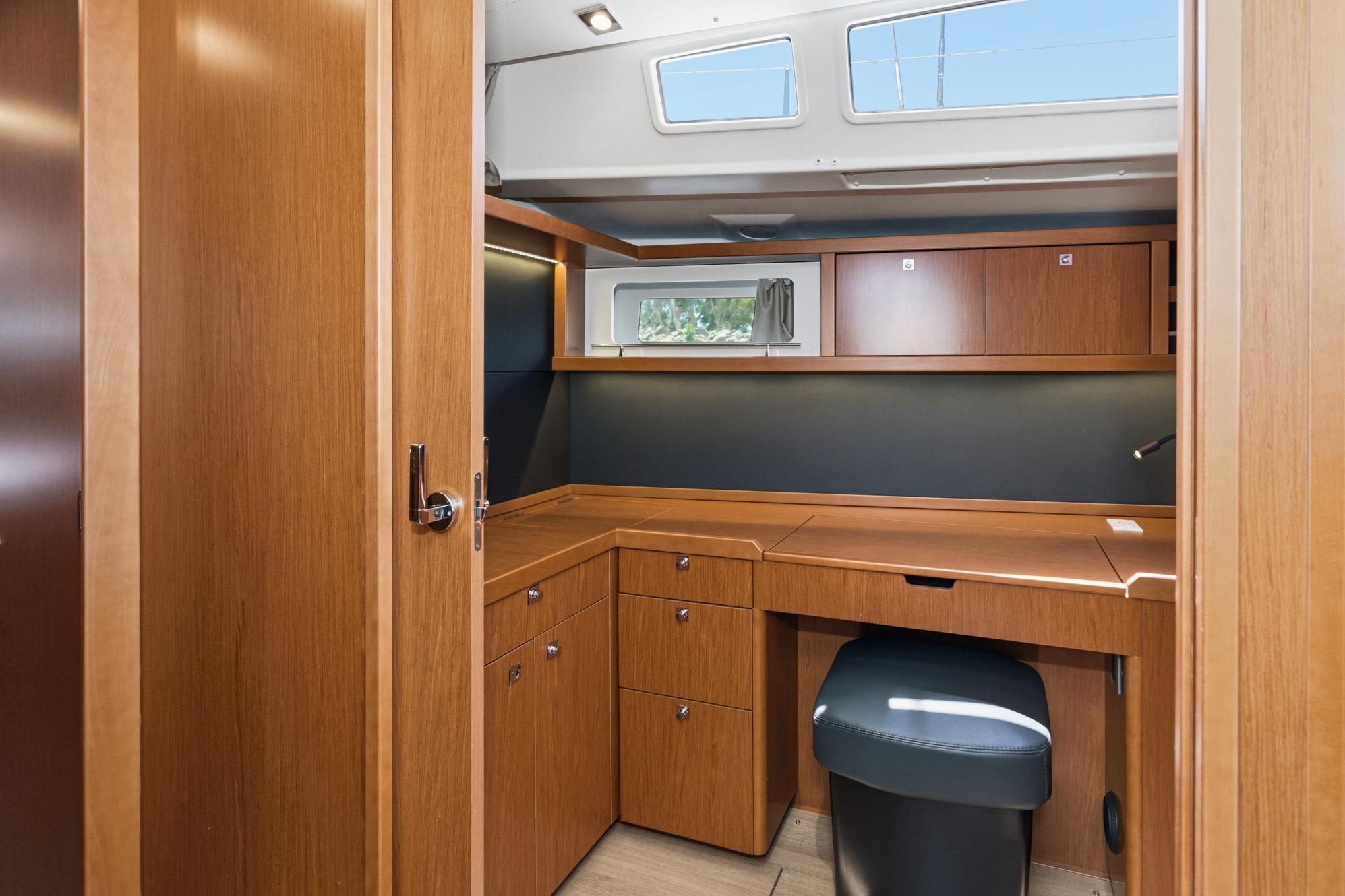 Interior of 2017 Beneteau Sense 50 yacht, featuring a wooden desk and storage cabinets.