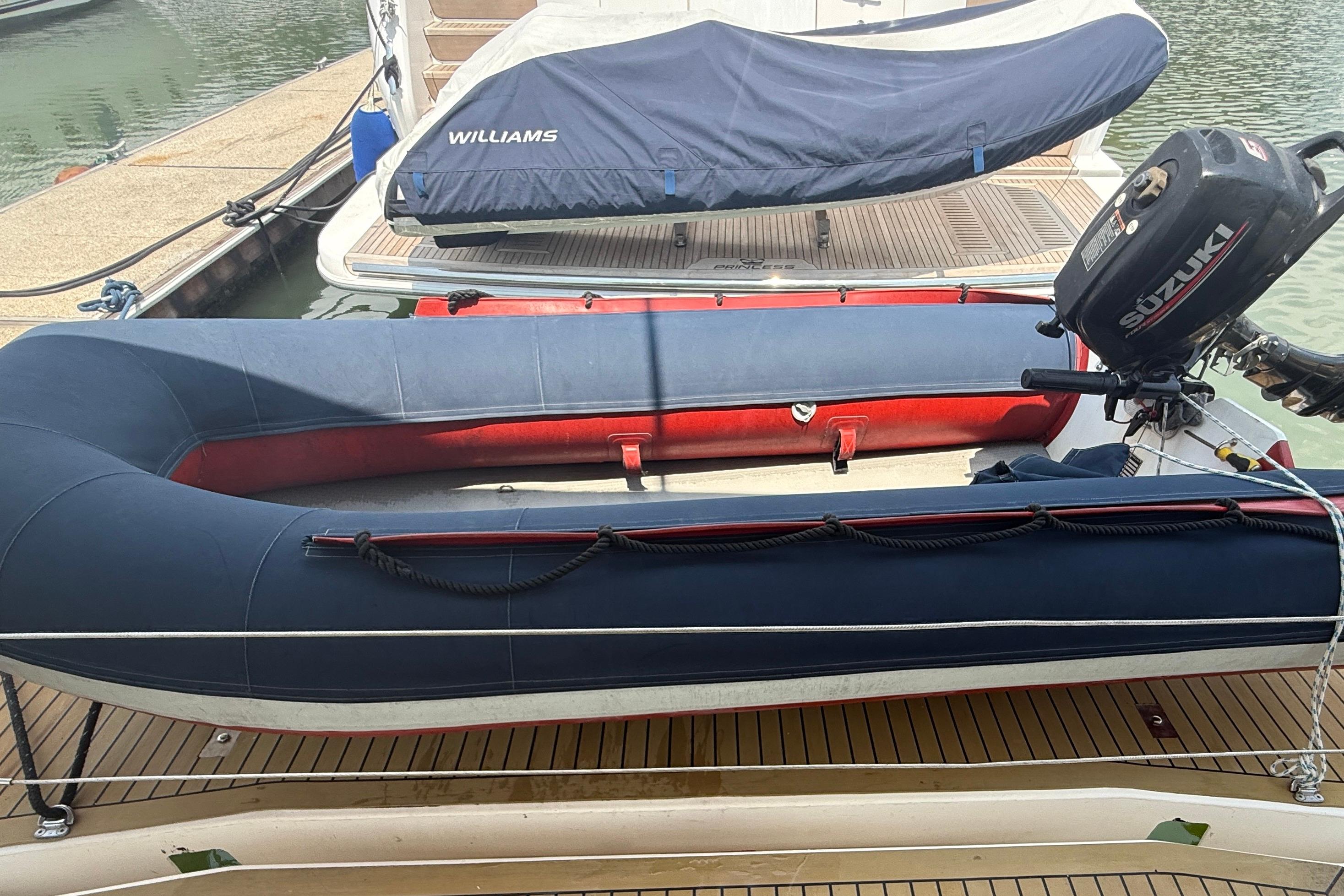 Inflatable boat with Suzuki motor docked beside Leopard 51 Powercat, 2015 model.
