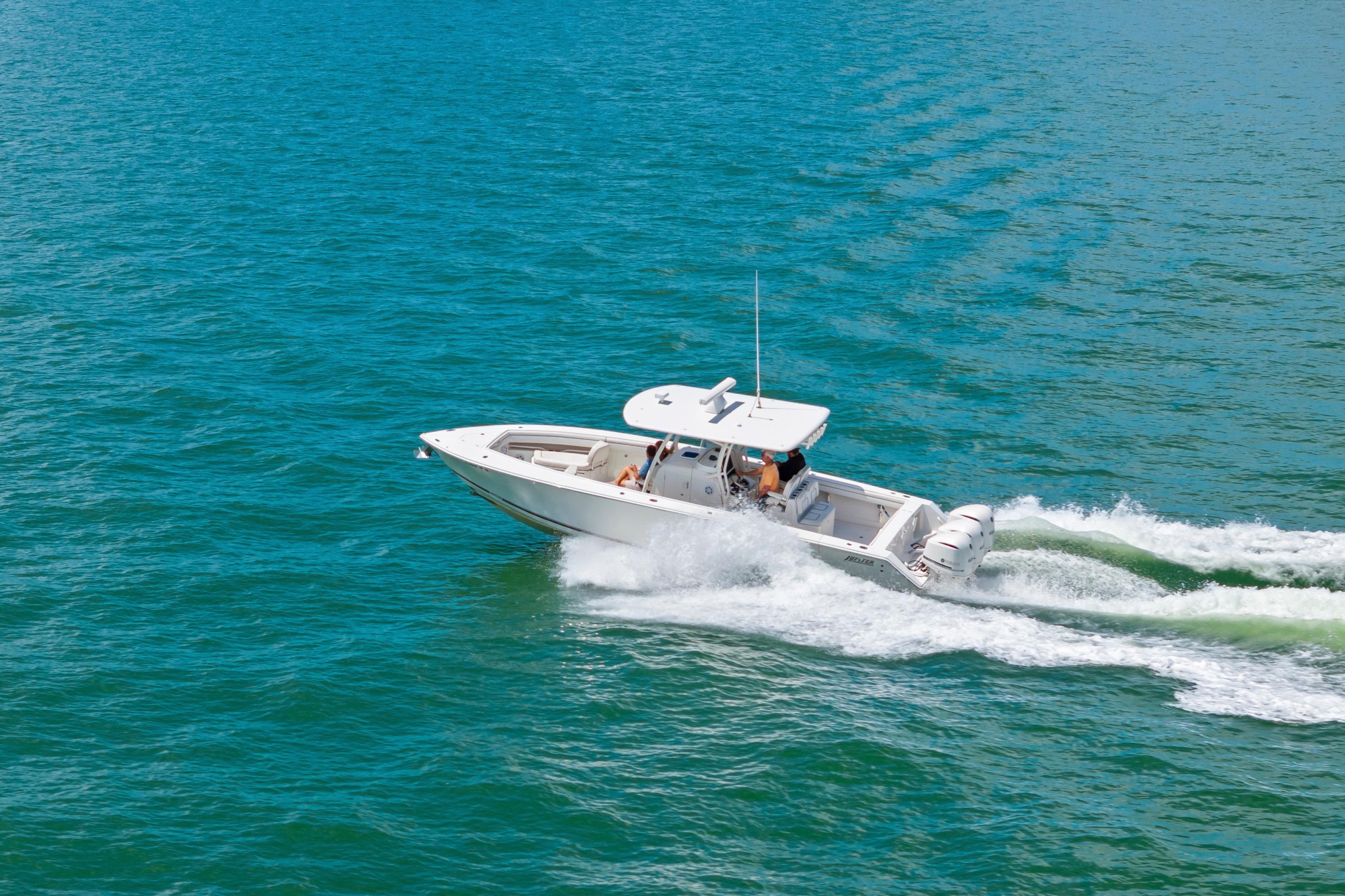 2015 Jupiter 34 HFS boat cruising on clear blue water.