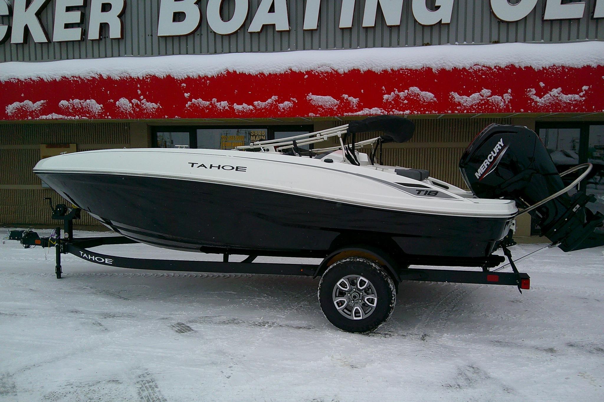 2026 Tahoe T18 boat on trailer in snowy dealership lot.