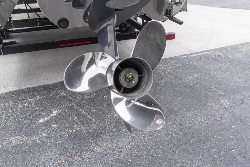 Propeller of 2026 SunCatcher Elite 326 SS boat on pavement background.
