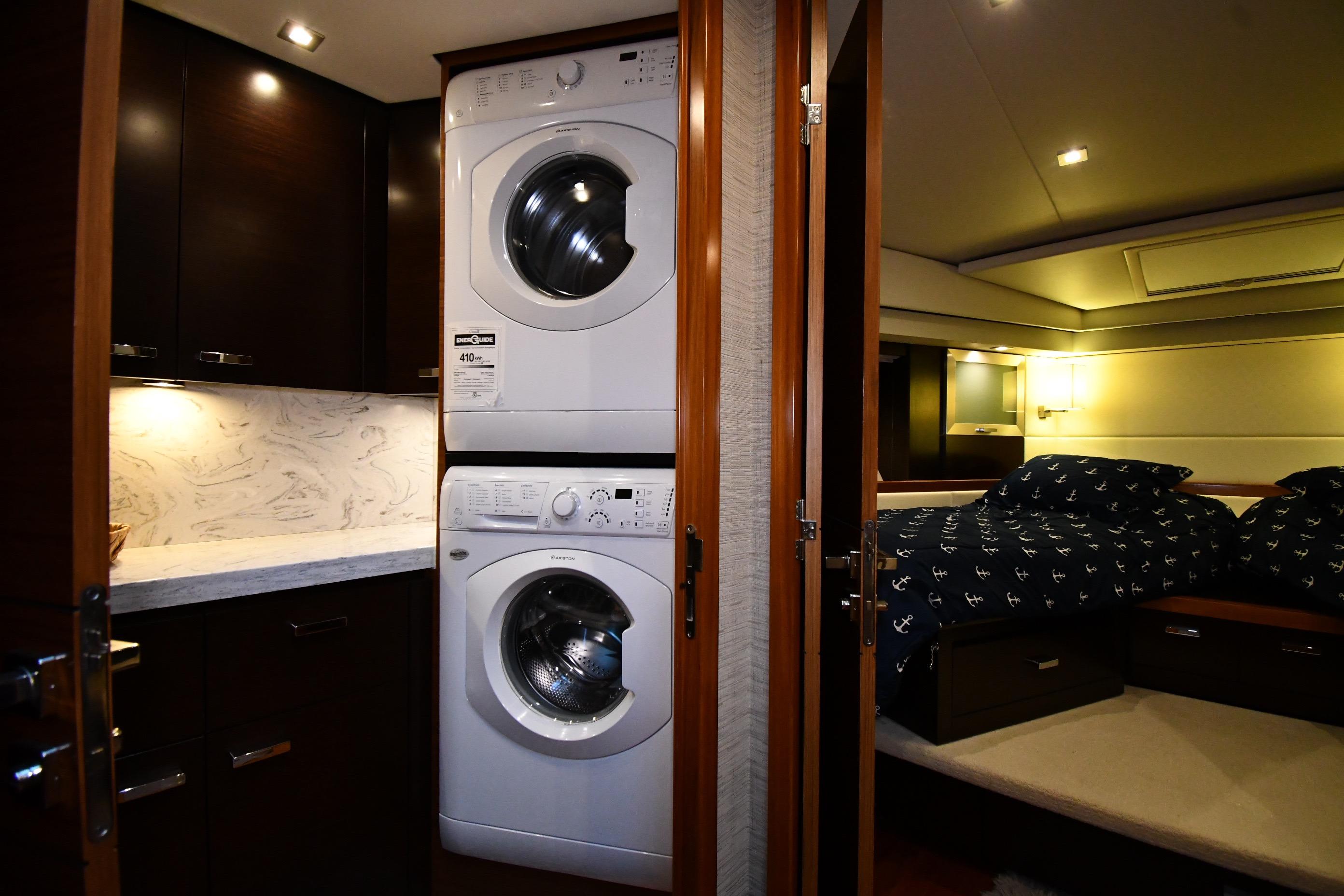 Laundry area and bedroom inside a 2016 Tiara Yachts 50 Coupe, featuring modern amenities.