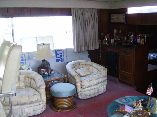 Interior of a 1980 Pluckebaum Baymaster with cozy seating and a small bar area.