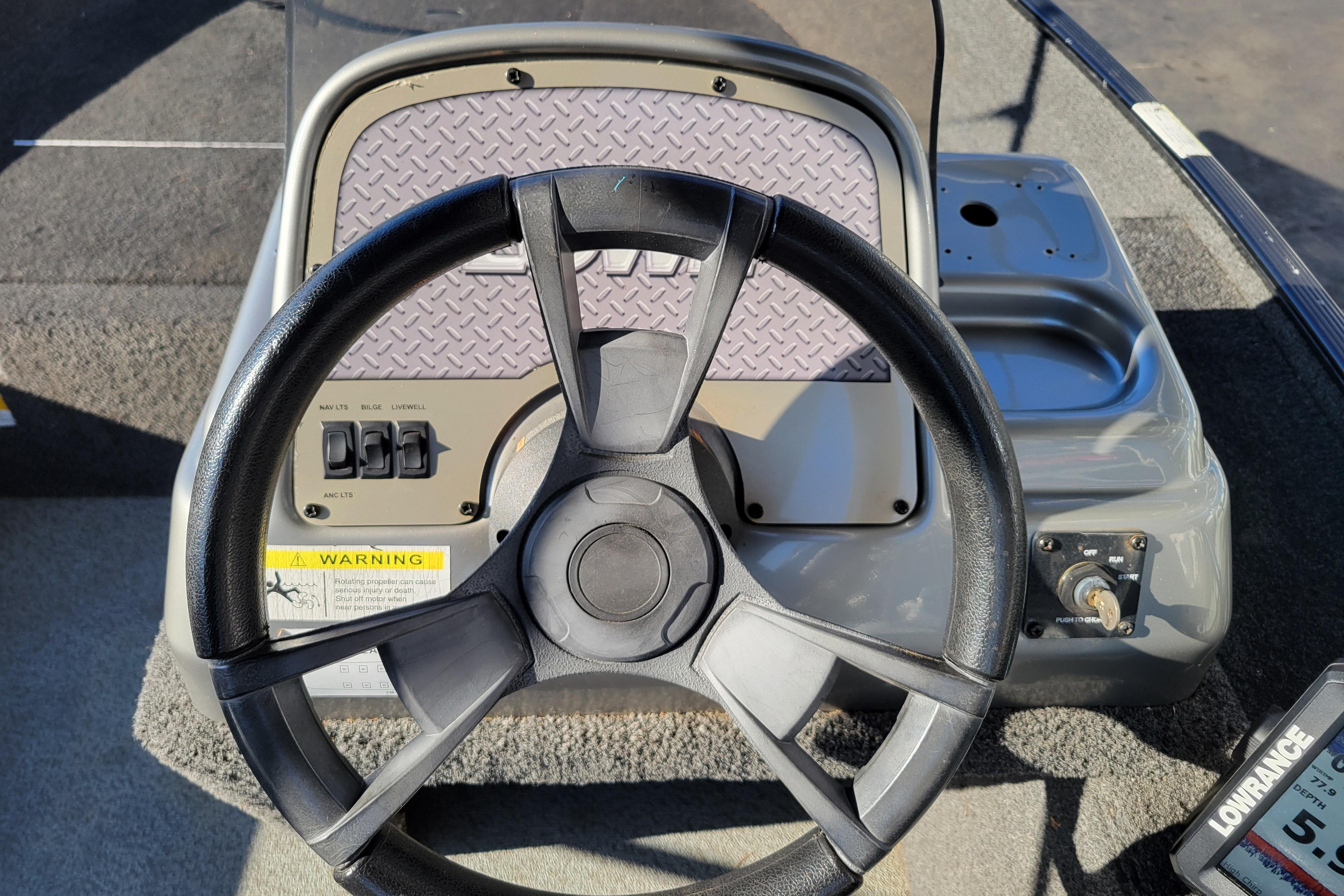 Steering wheel of 2017 Lowe Fishing Machine 160S boat with control panel.