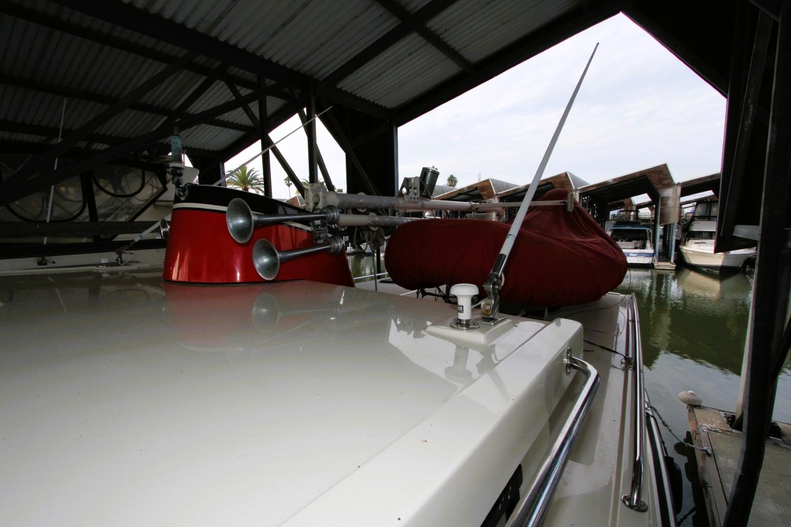 2002 Nordic Tug 37 docked under a covered marina, showcasing deck details.