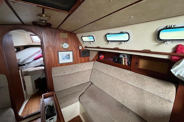 1983 CS 33 sailboat interior with cozy seating, wooden accents, and porthole windows.