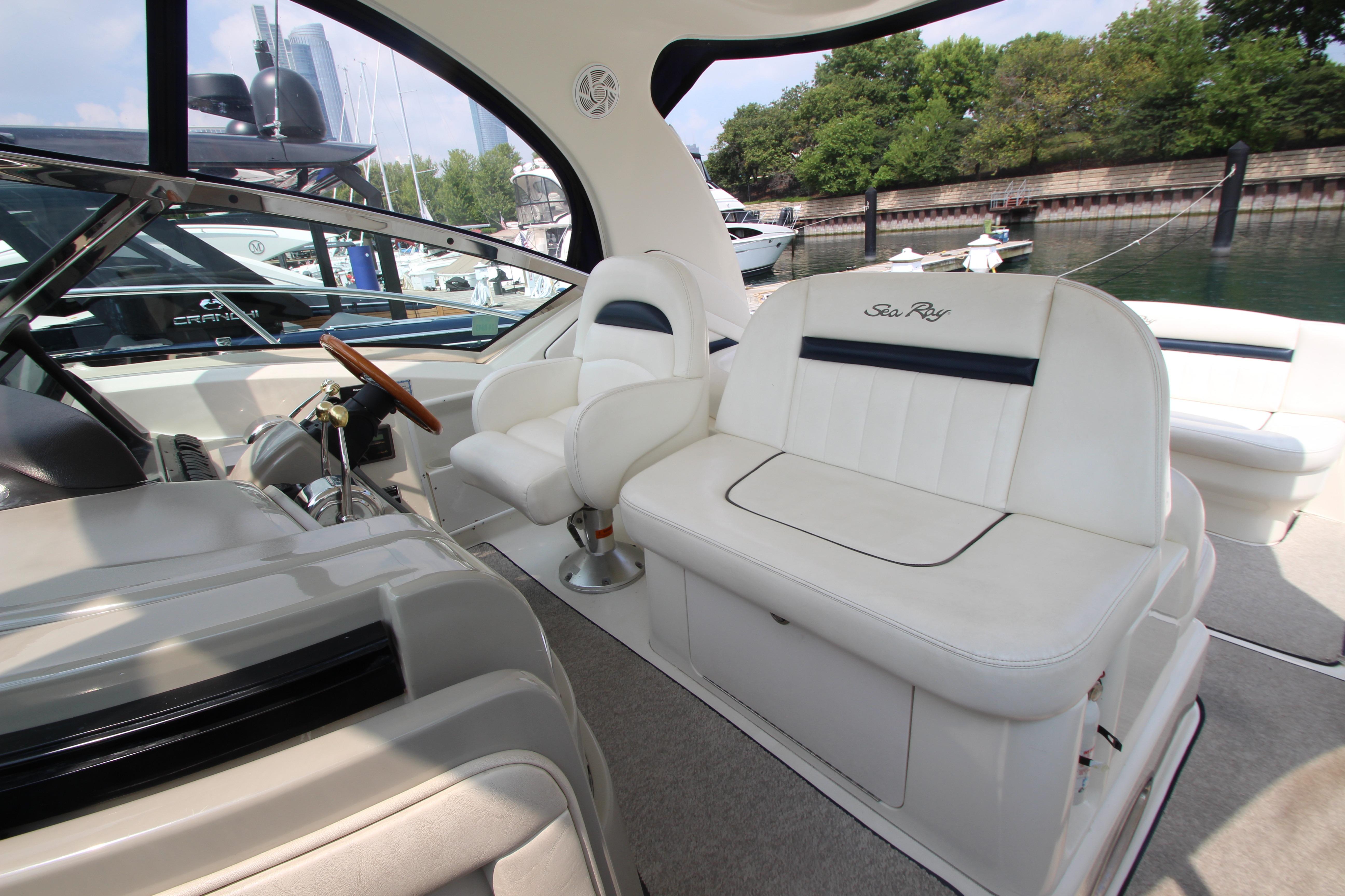 Interior of 2004 Sea Ray 40 Sundancer yacht with white seating and steering wheel.