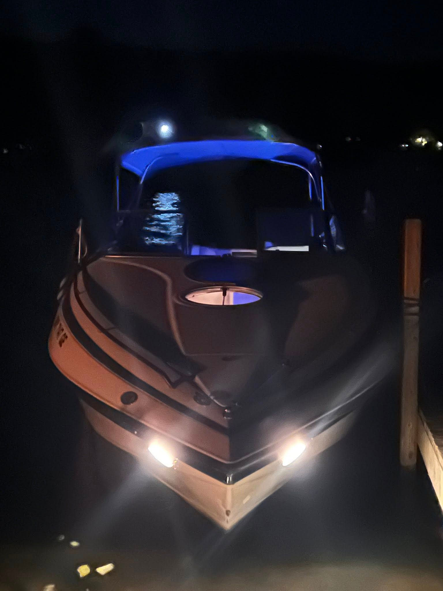 1999 Crownline 266 CCR boat at night with lights on.