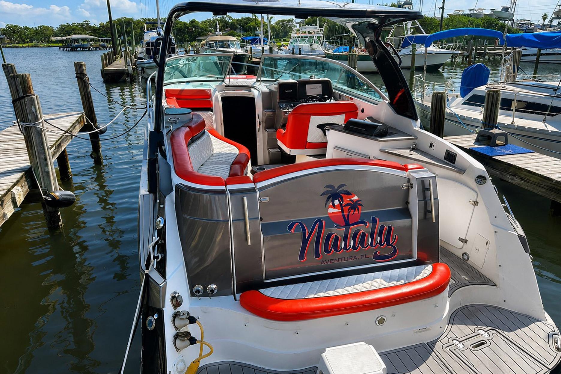 2012 Rinker 310 Express Cruiser LE docked, featuring red and white seating, with "Nataly" branding.