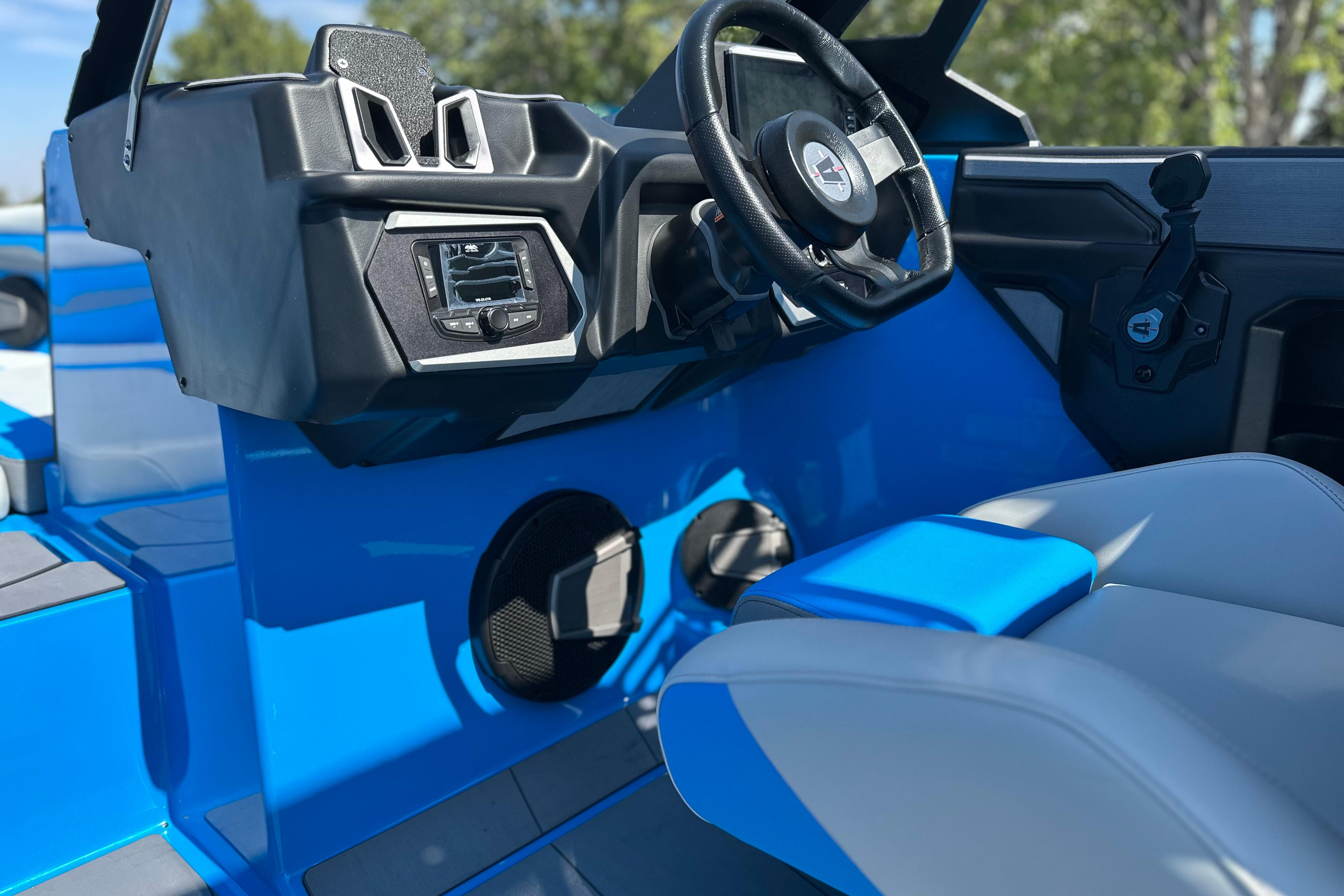 2026 Axis T235 boat interior with steering wheel and control panel, featuring blue and gray seating.