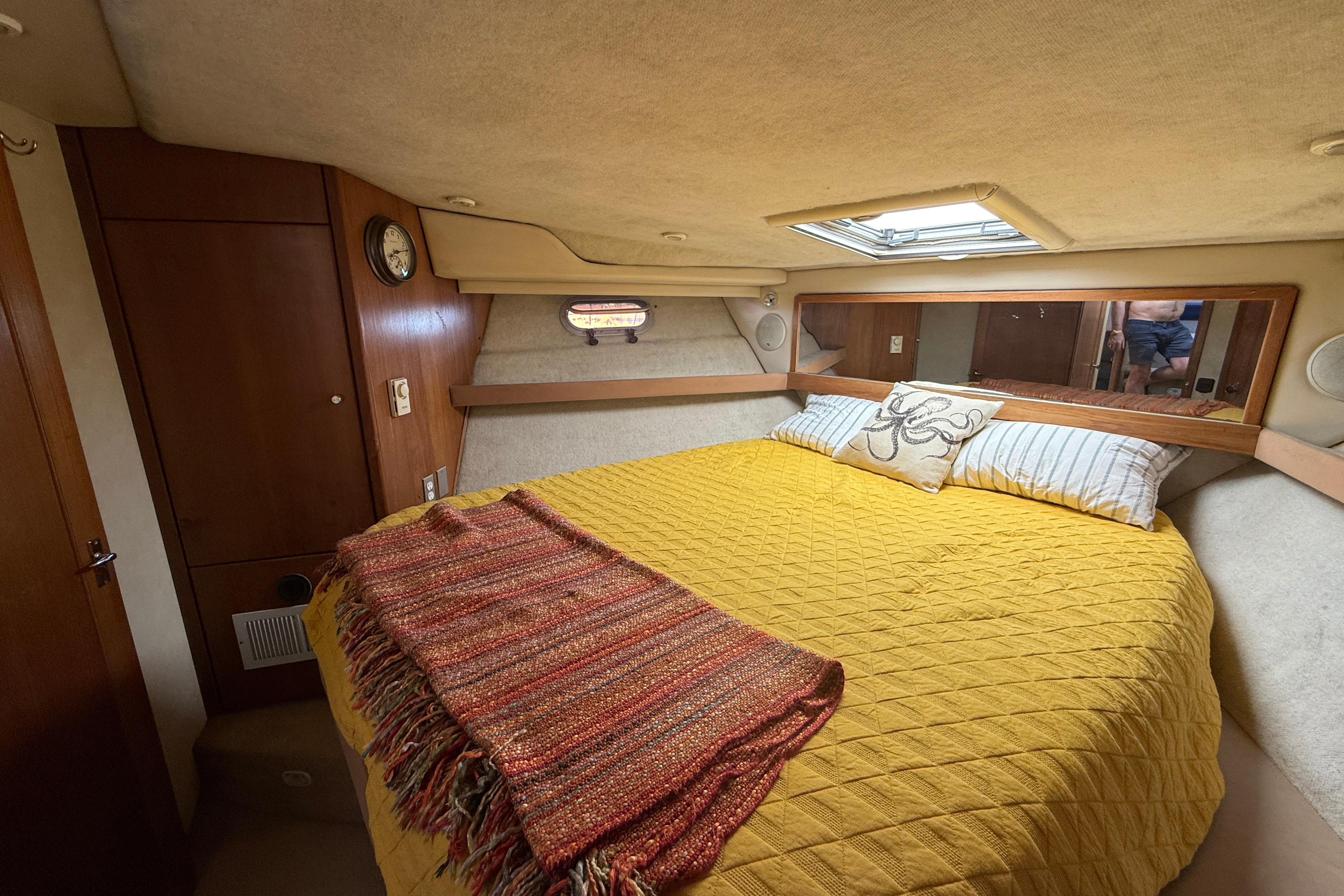 Cozy bedroom in 1997 Bayliner 3988 Command Bridge Motoryacht with yellow bedding and wood accents.