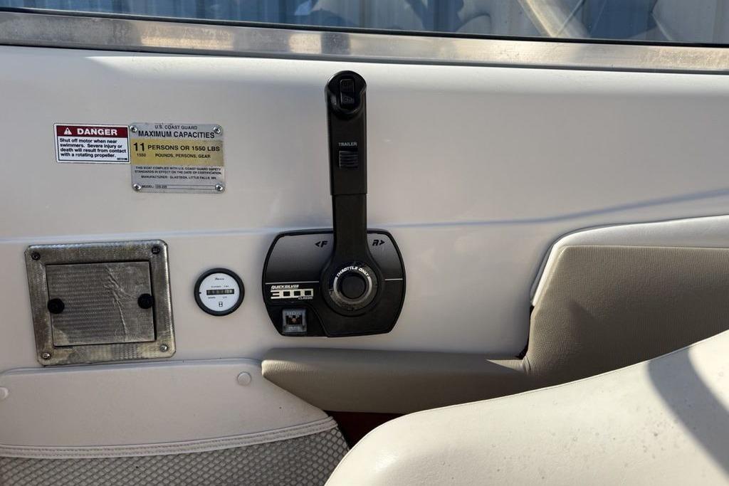 Control panel of a 1999 Glastron GT 225 boat with capacity warning label.