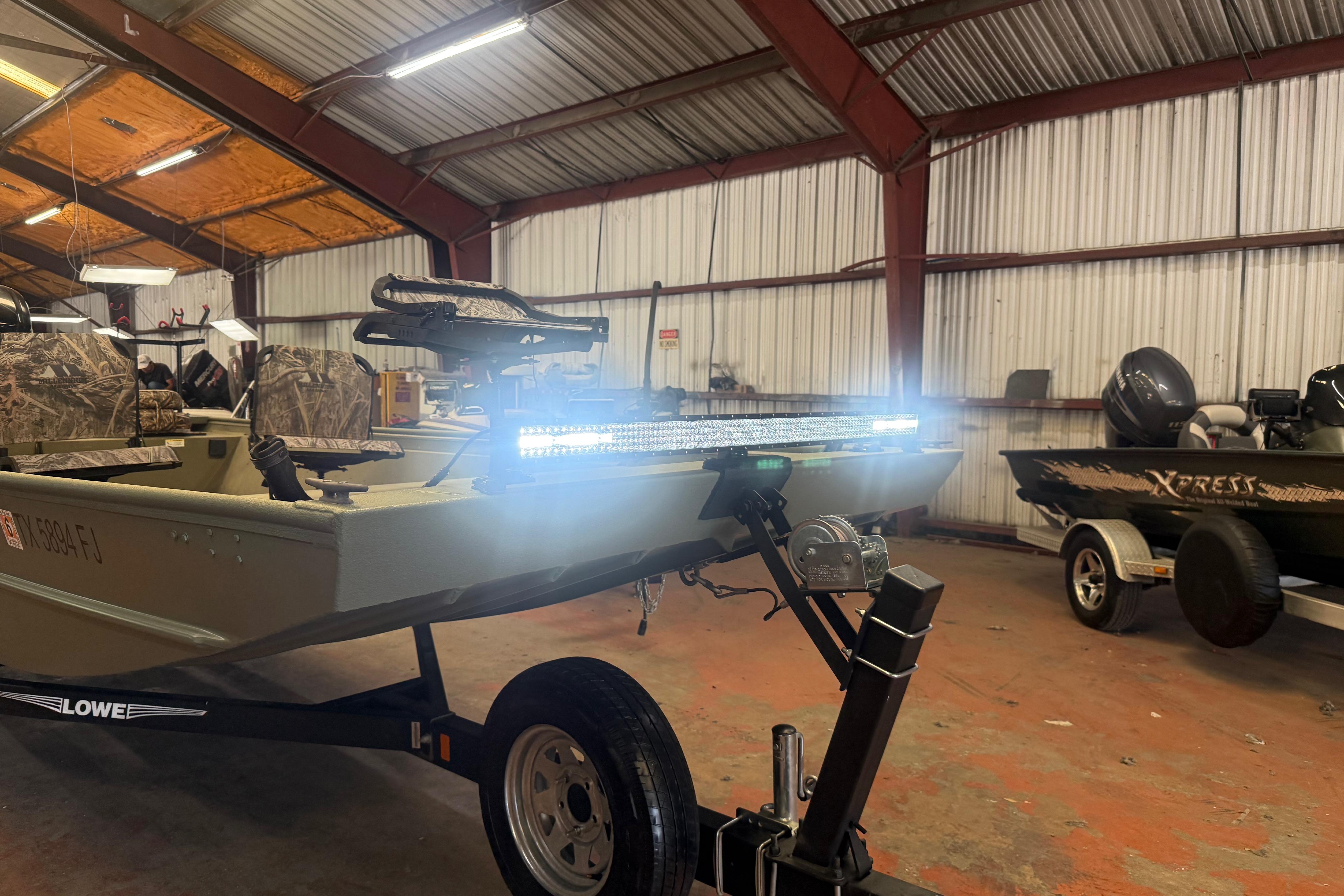 2020 Lowe Roughneck 2070 Big River boat with LED lights in a warehouse.