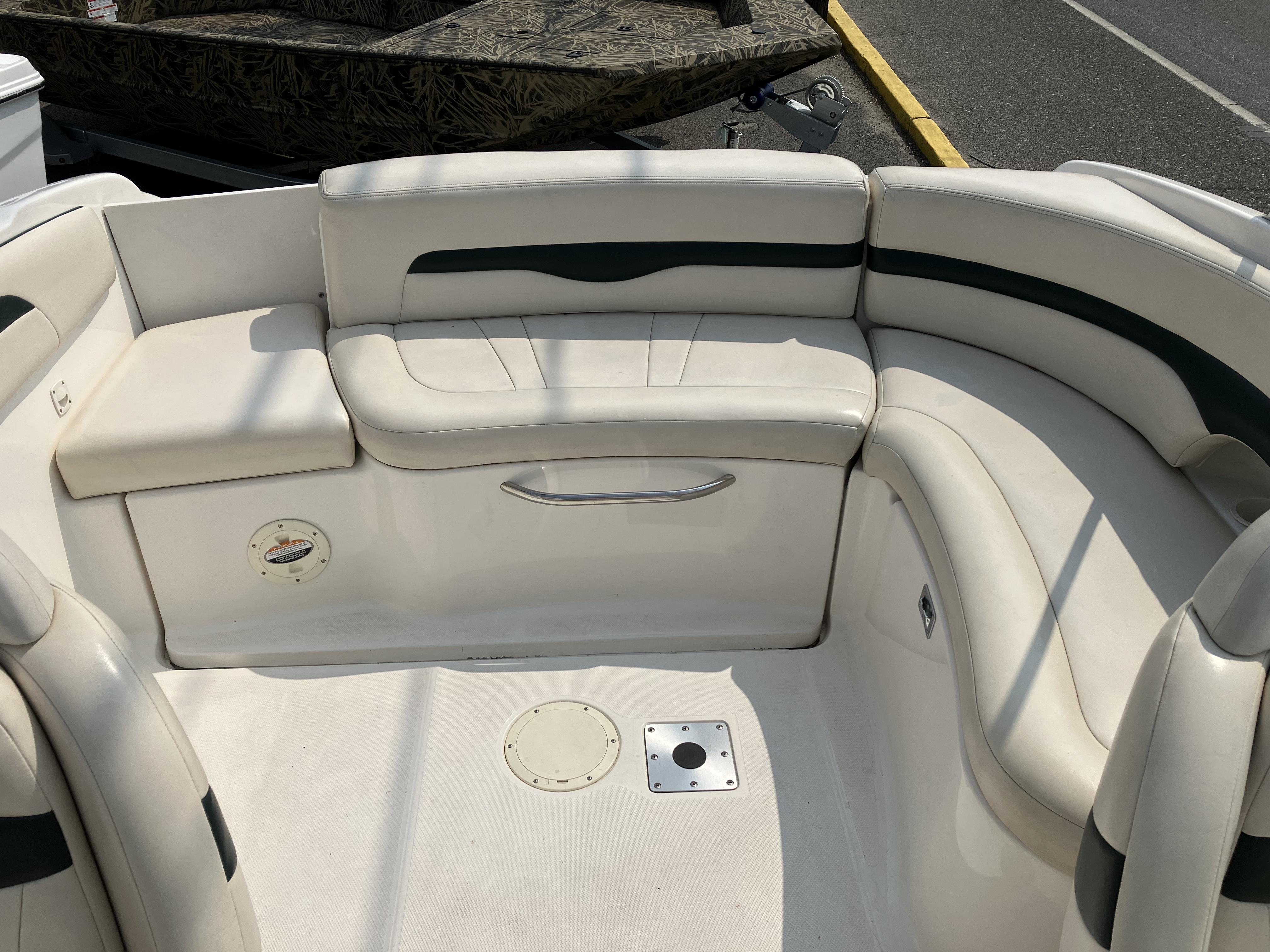 The image shows the cockpit of a 2001 Chaparral 235 SSi boat with white cushioned seating.