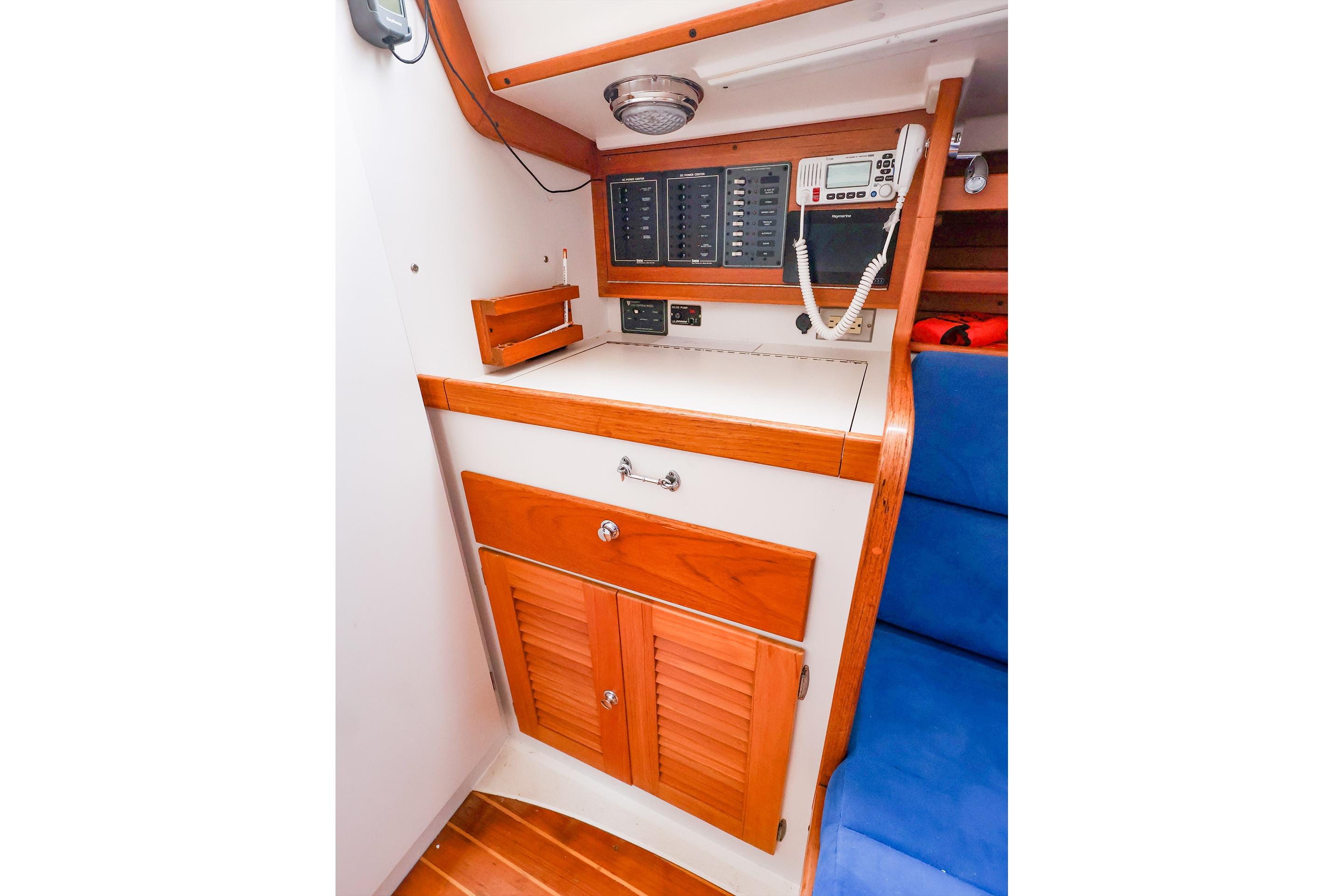 2001 J Boats J/32 interior with control panel, wooden cabinetry, and blue seating.