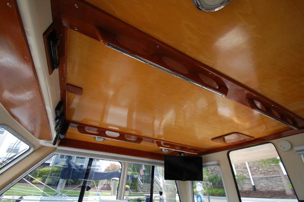 Interior view of a boat with a wooden ceiling and windows.