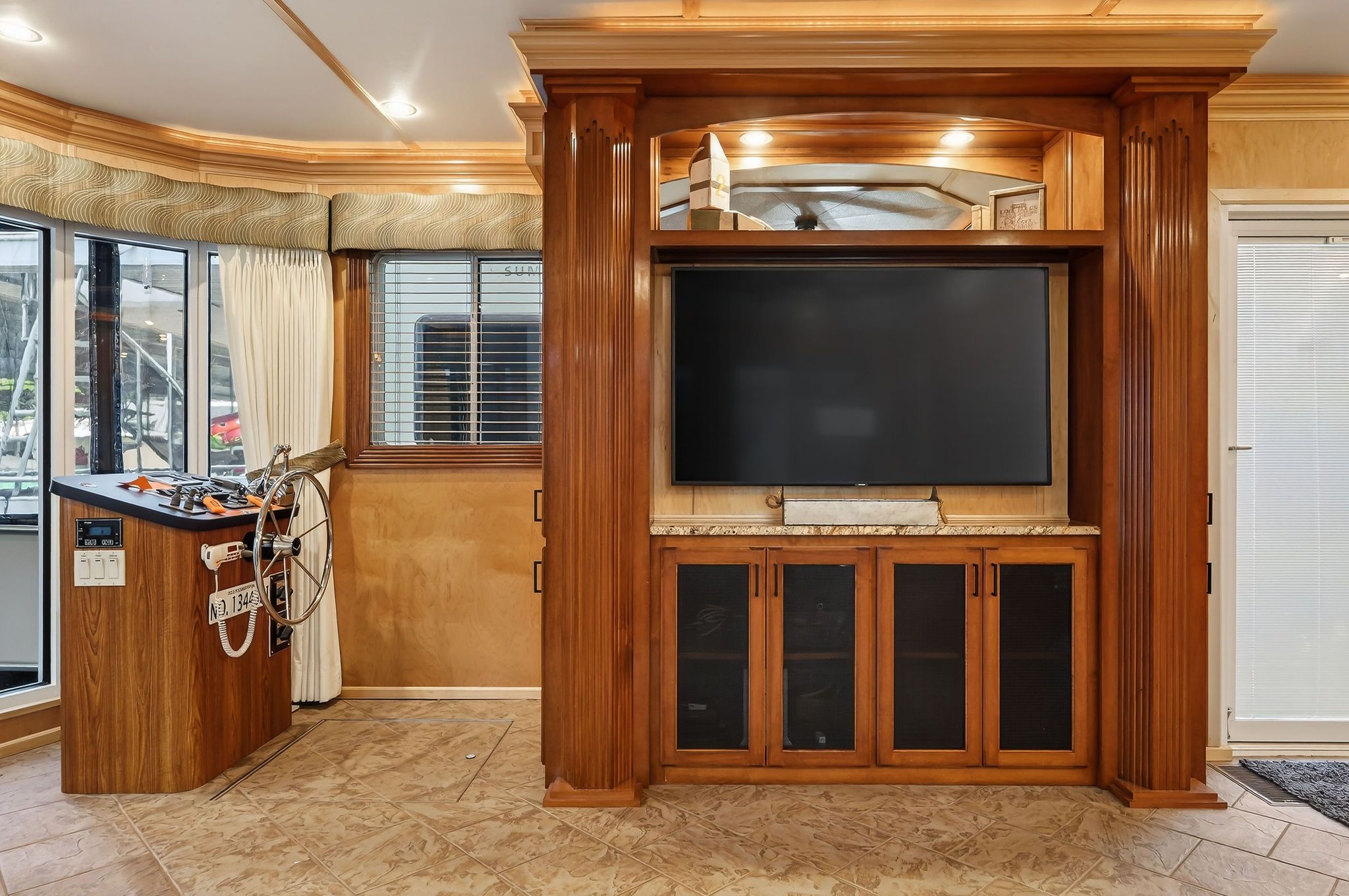 Interior of a 2010 Houseboat Throughbred with wood paneling and large TV.