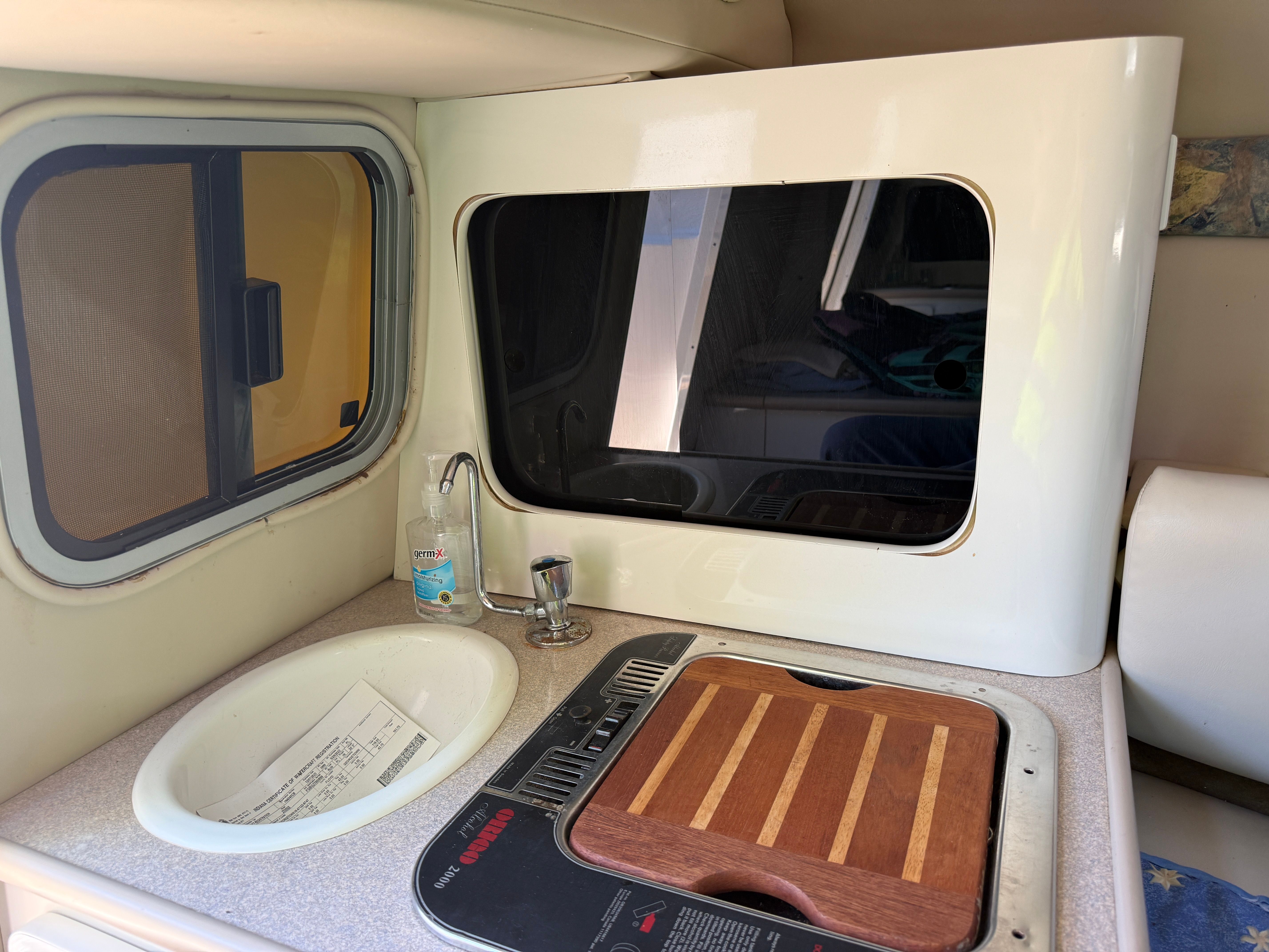 Interior of 1999 Custom 2335 Cuddy cabin with sink and stove.