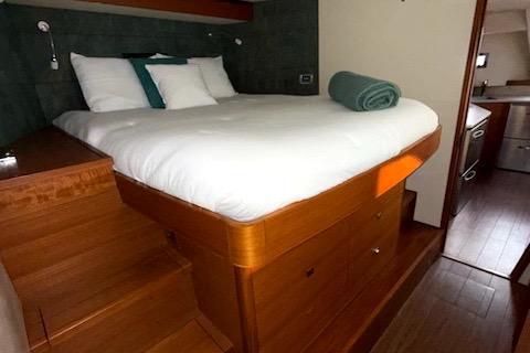 Luxurious bedroom interior of 2015 Gunboat 57' yacht with wooden furnishings and cozy bedding.