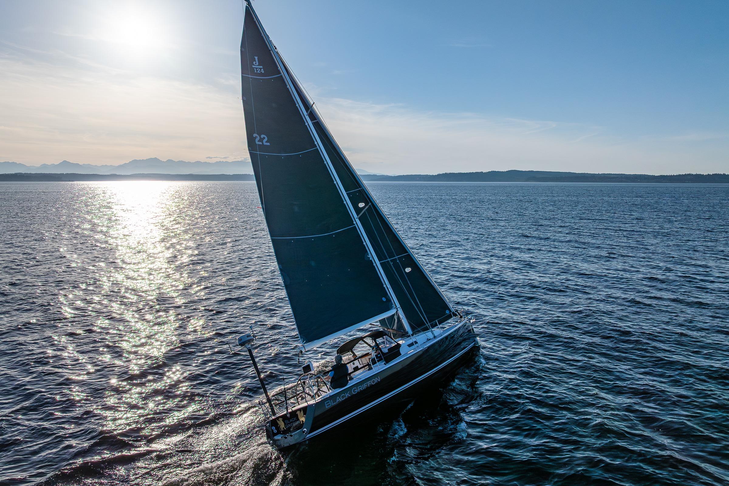 Sailing yacht J/124 from 2007 gliding on open water at sunset.