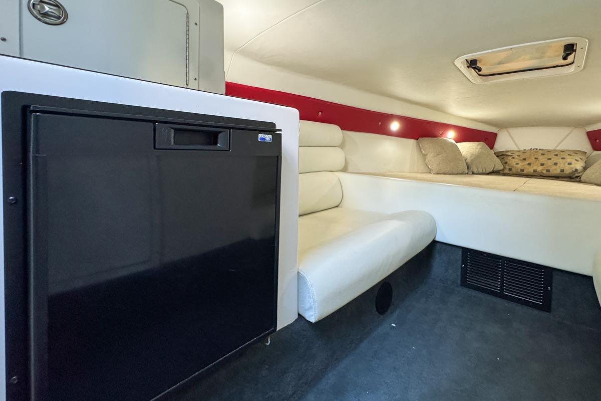 2022 Velocity 290sc cabin interior with seating, bed, and compact refrigerator.