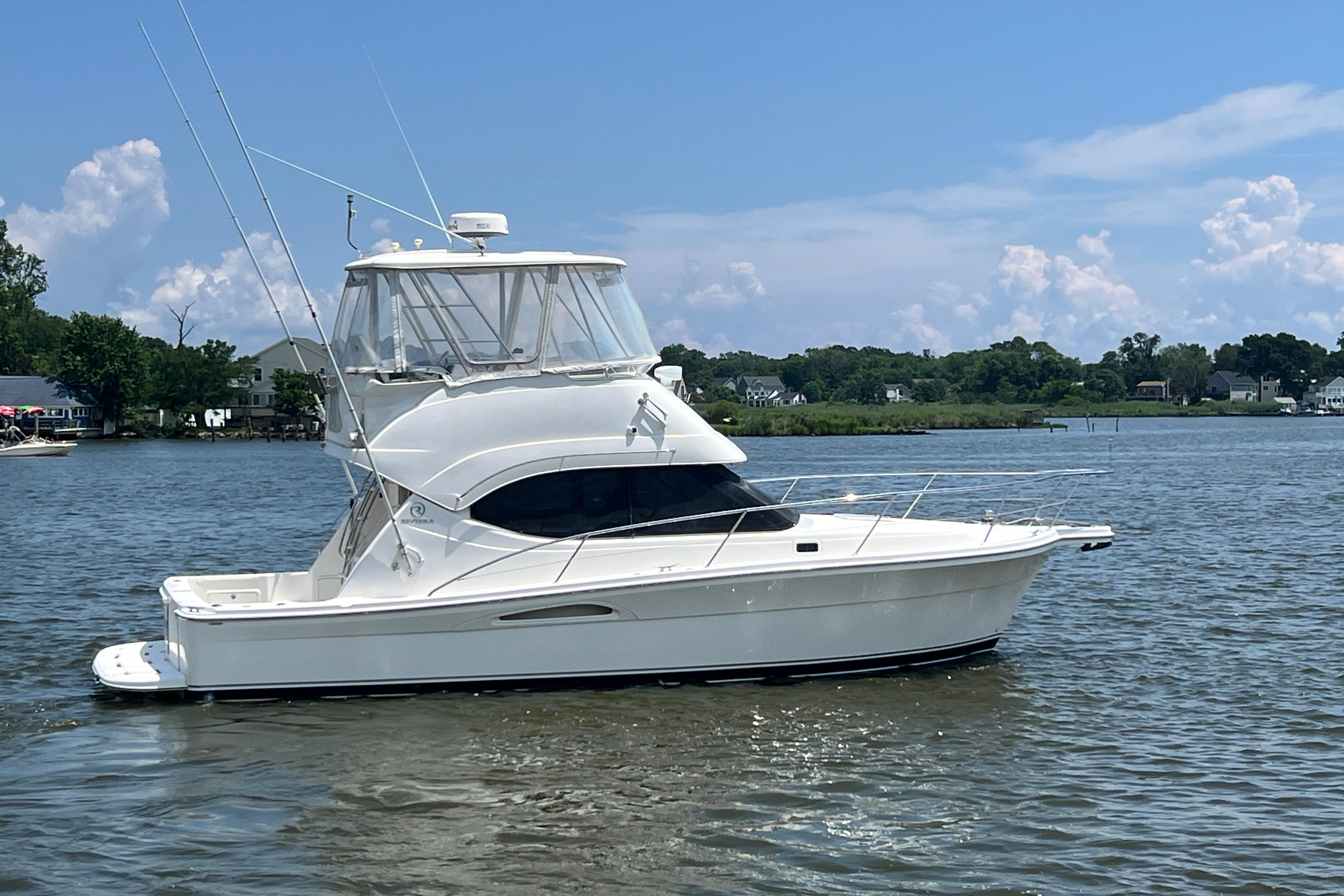 2007 Riviera 33 Flybridge yacht on calm water under a clear blue sky.