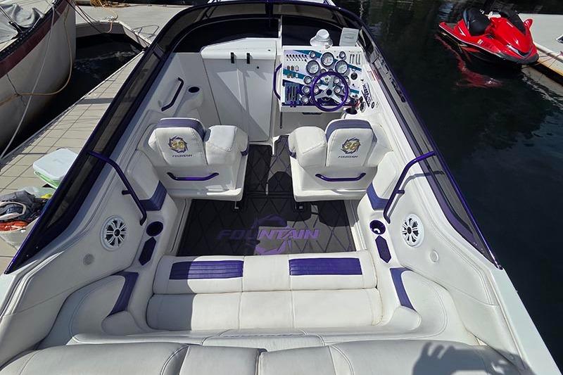 2004 Fountain 38 Lightning boat interior with white and purple seating, dashboard, and controls.