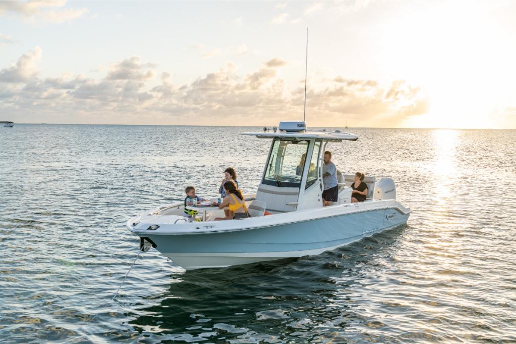 2024 Boston Whaler 280 Dauntless boat on water at sunset with people onboard.