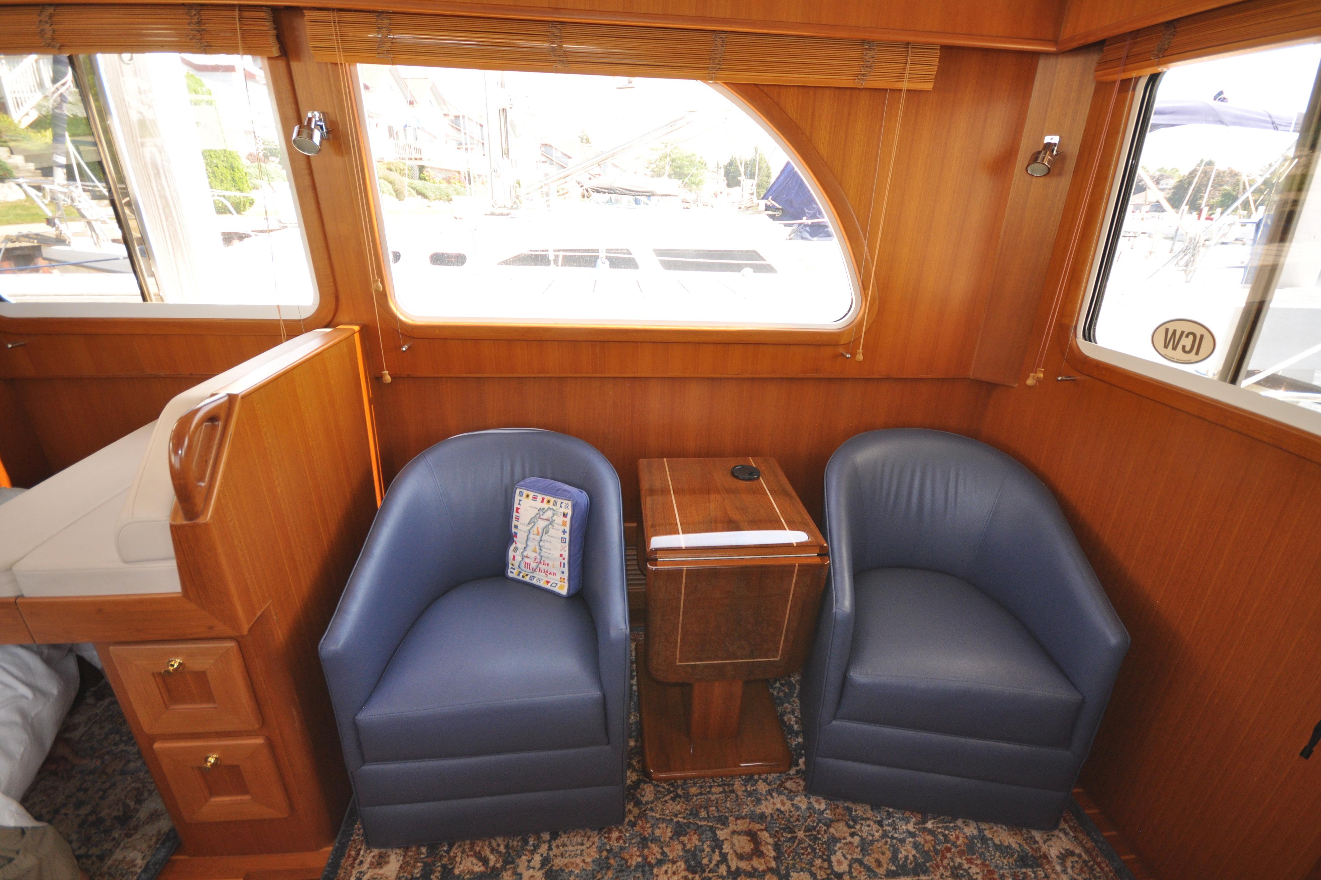 Interior of 2015 Helmsman Trawlers 31 Sedan with blue chairs and wooden accents.