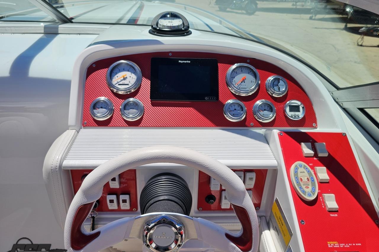 2005 Formula 271 FASTech boat dashboard with gauges and steering wheel in red and white.