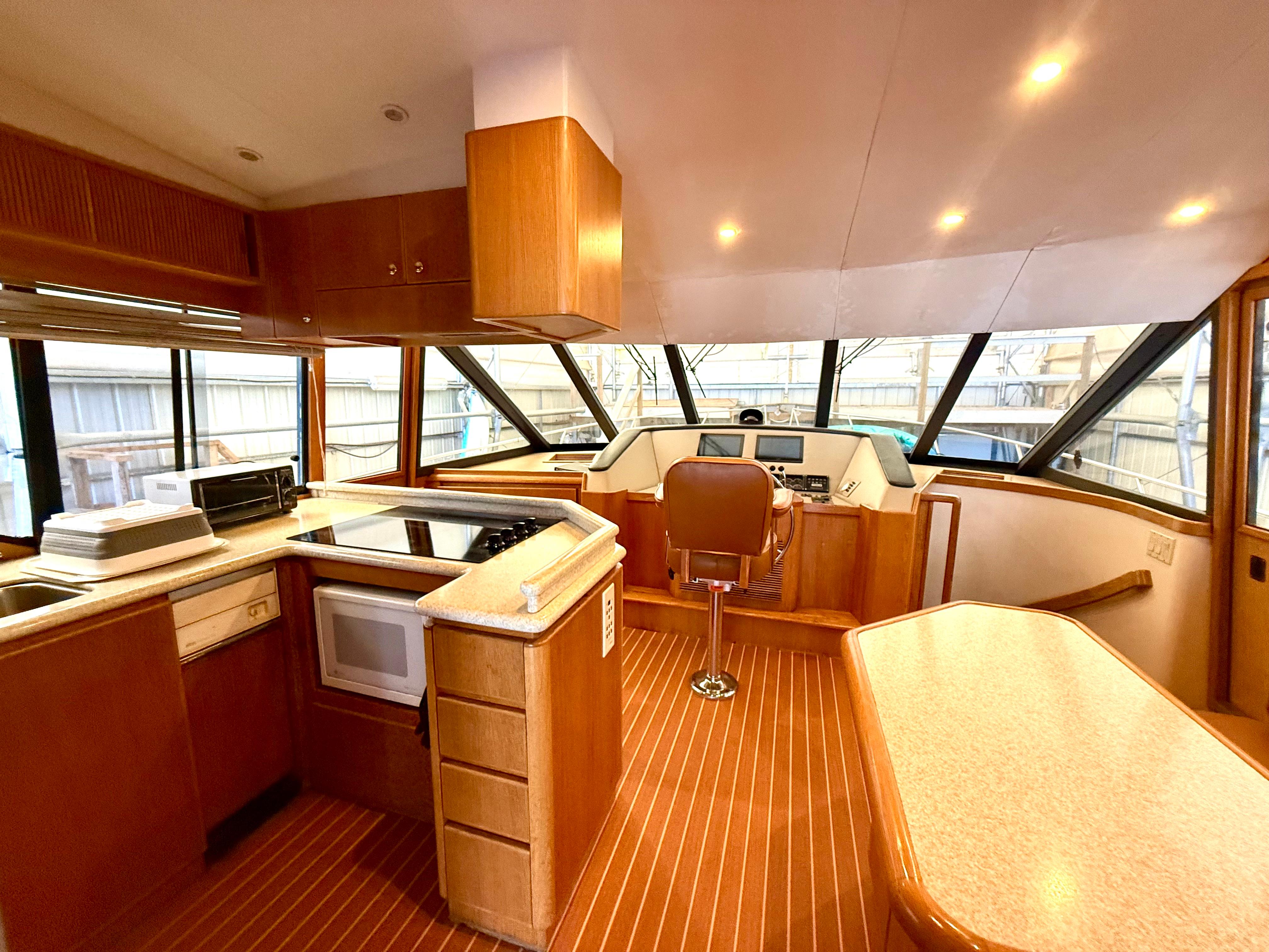 Interior of 1997 West Bay Sonship 58 Pilothouse with kitchen and helm station.