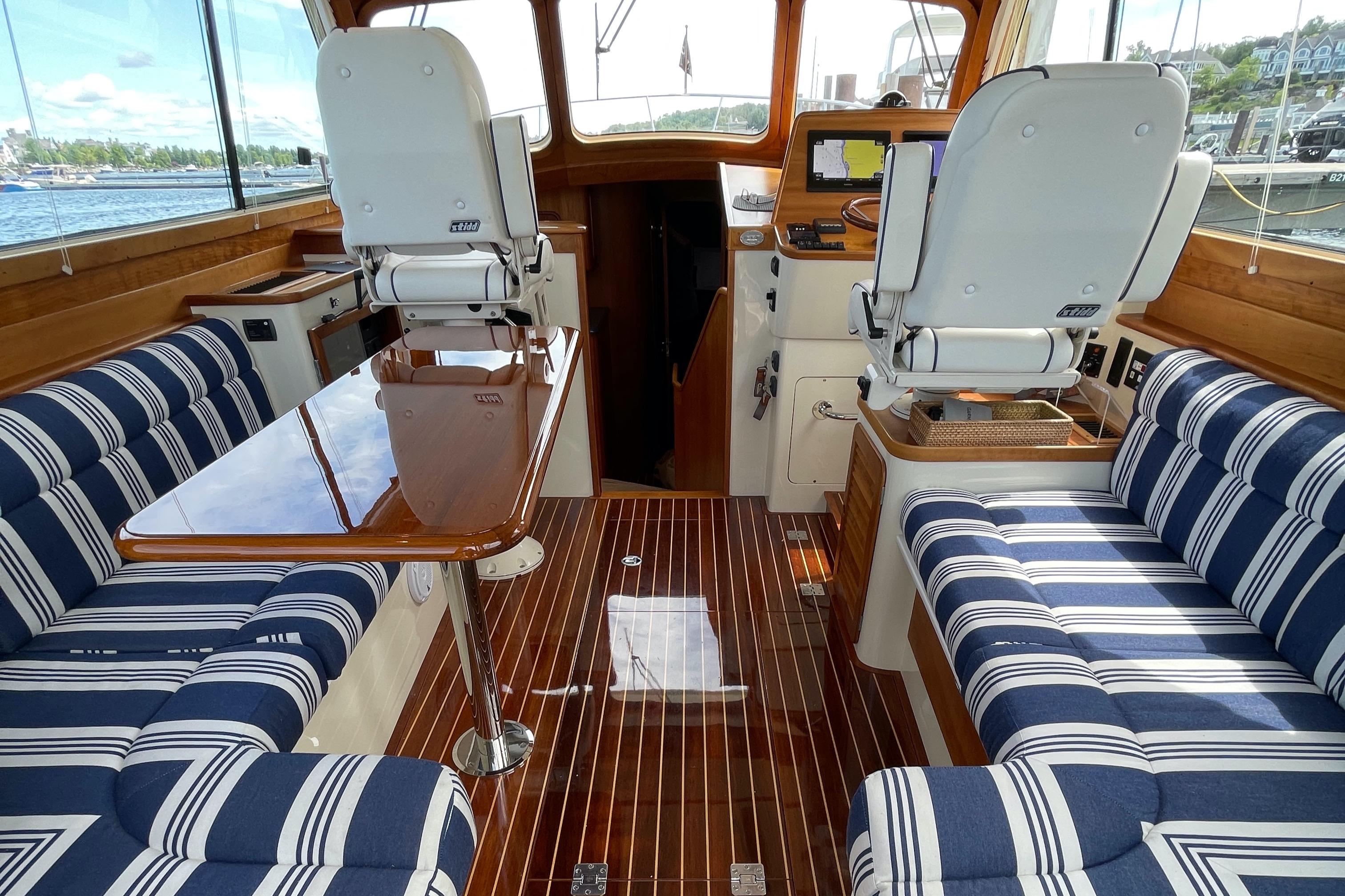 Interior of 2007 Hinckley Talaria 44 Flybridge with striped seating and wooden flooring.