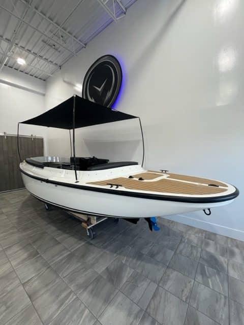 2023 Vision Marine Technologies Fantail 217 boat displayed indoors with canopy.