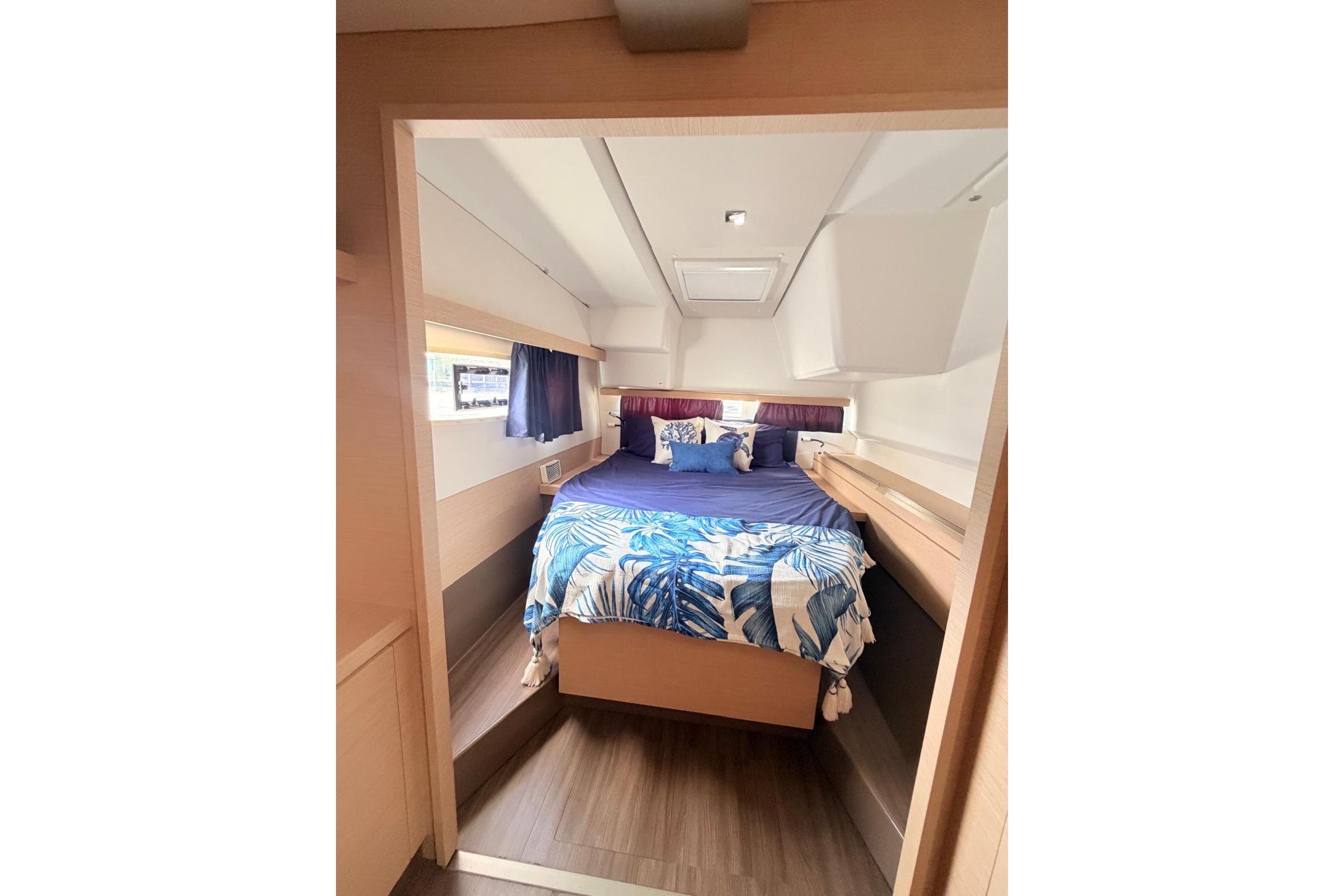Cozy cabin interior of 2018 Fountaine Pajot Lucia 40 catamaran with bed and window.