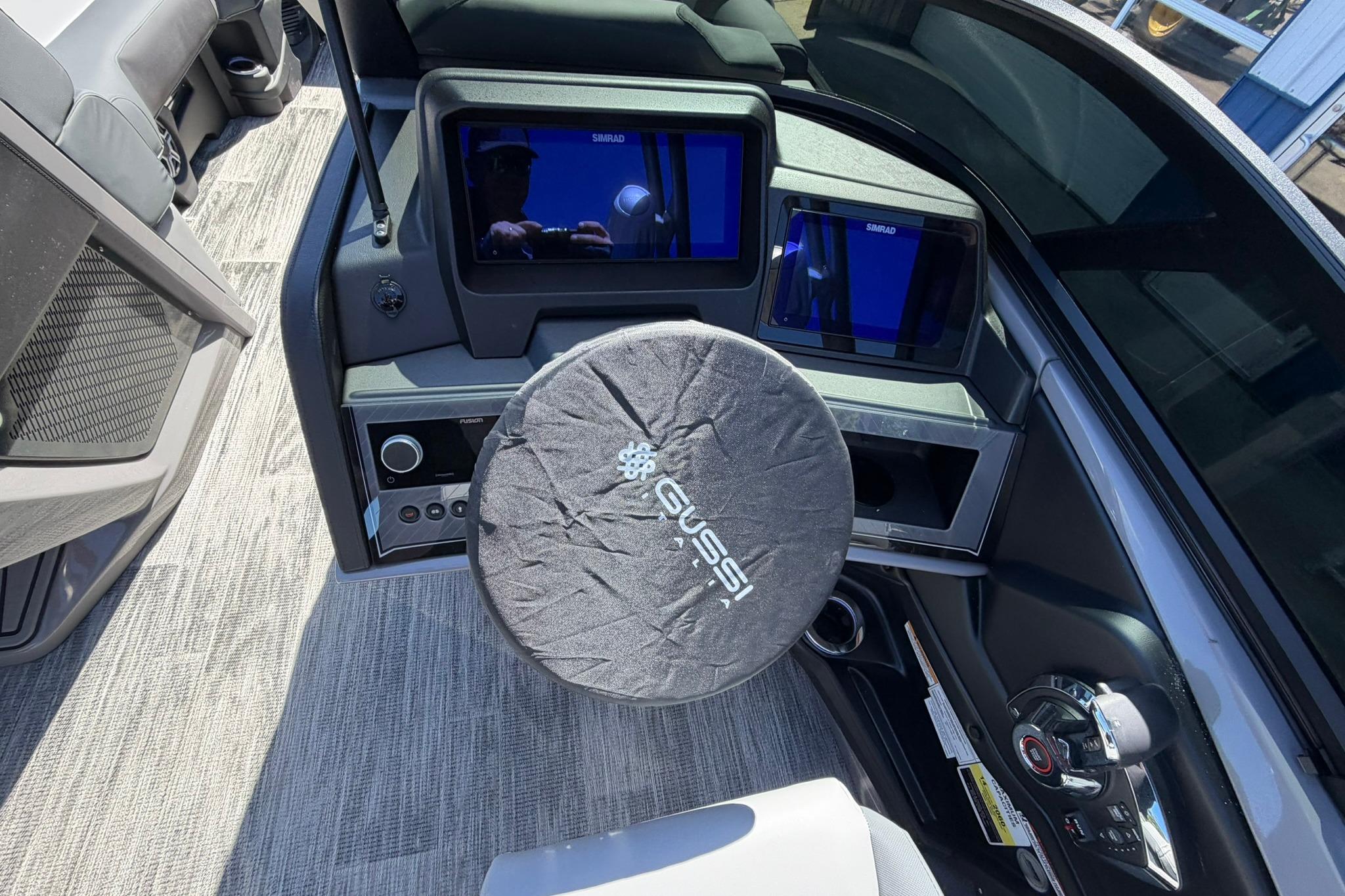Interior of 2026 Avalon Excalibur LTD boat with modern dashboard and steering wheel cover.