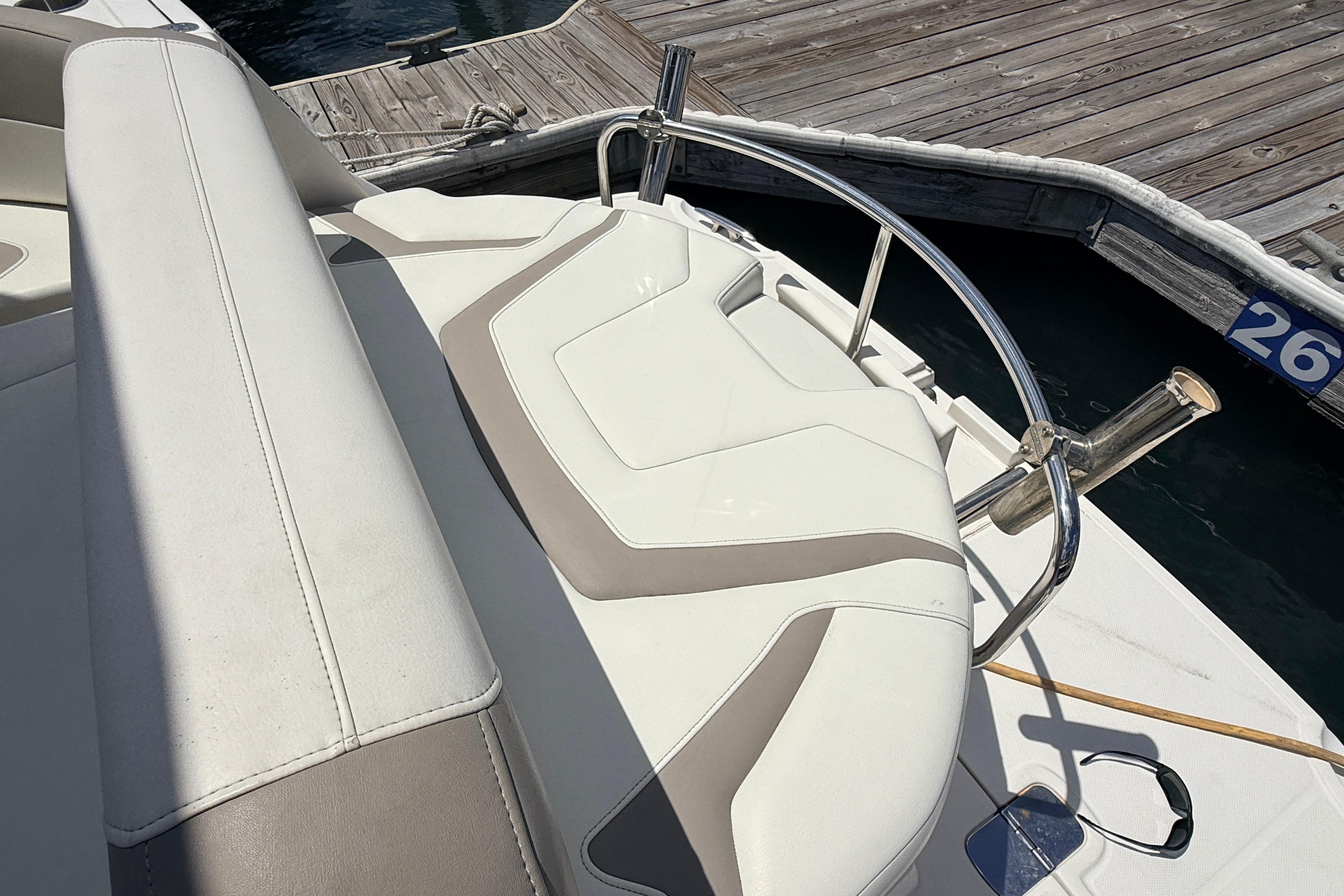 2011 Monterey 320 Sport Yacht seating area by dock, featuring sleek white upholstery.
