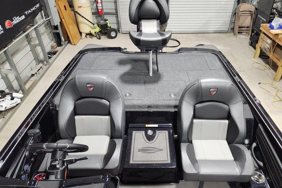 2026 Triton 20XP Patriot boat interior with dual seats and steering wheel in a garage setting.