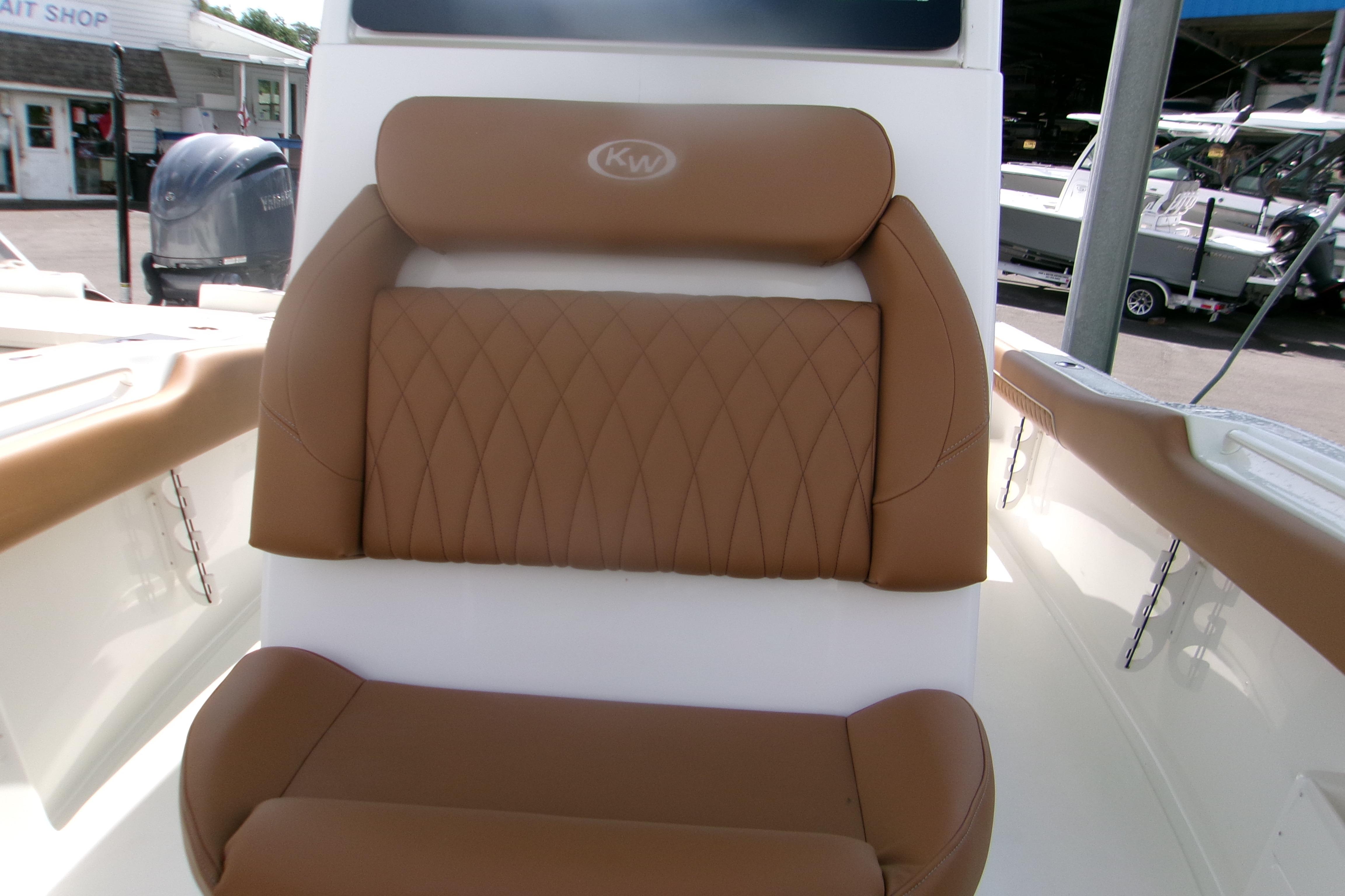 2027 Key West 249 FS boat with brown cushioned seating, docked near a bait shop.