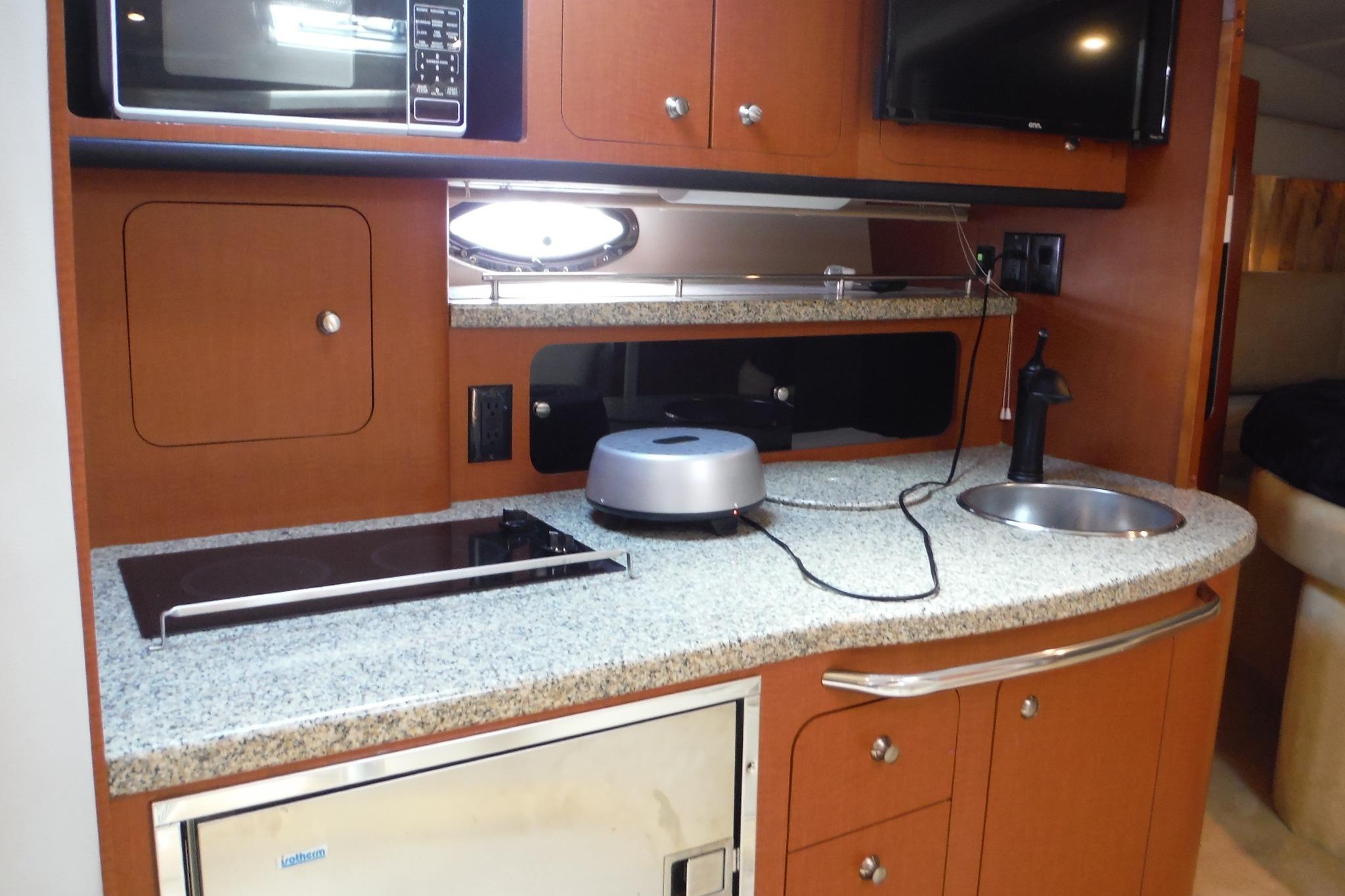 2005 Chaparral Signature 350 yacht kitchen with microwave, stove, and sink.