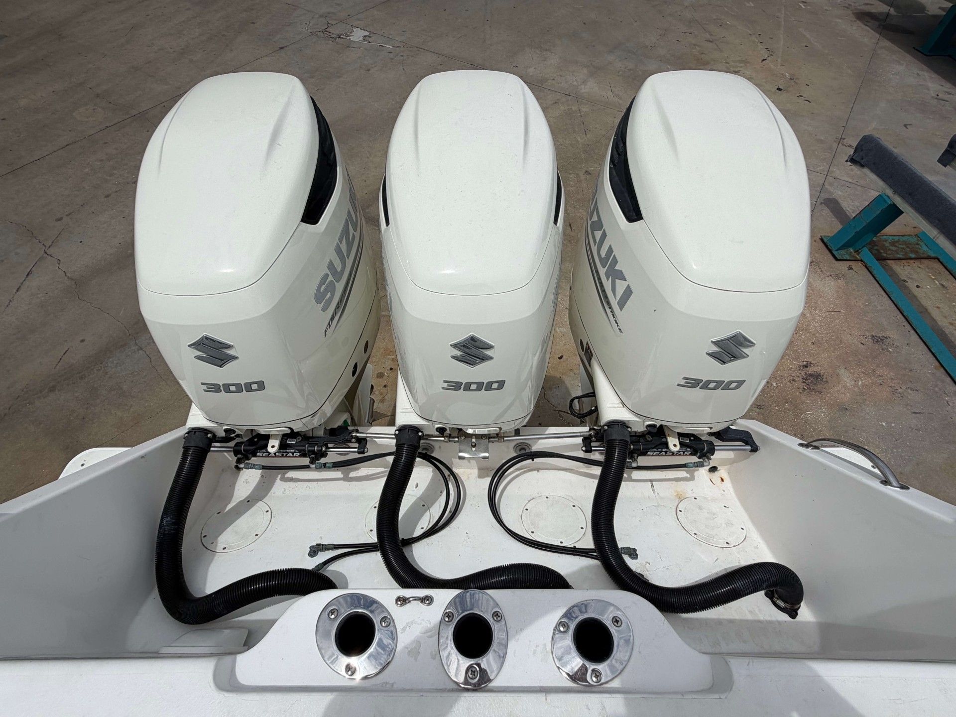 Three Suzuki 300 horsepower outboard engines are mounted on the stern of a boat.
