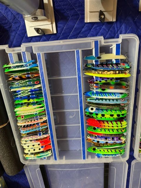 A box of colorful fishing lures, neatly organized in compartments.