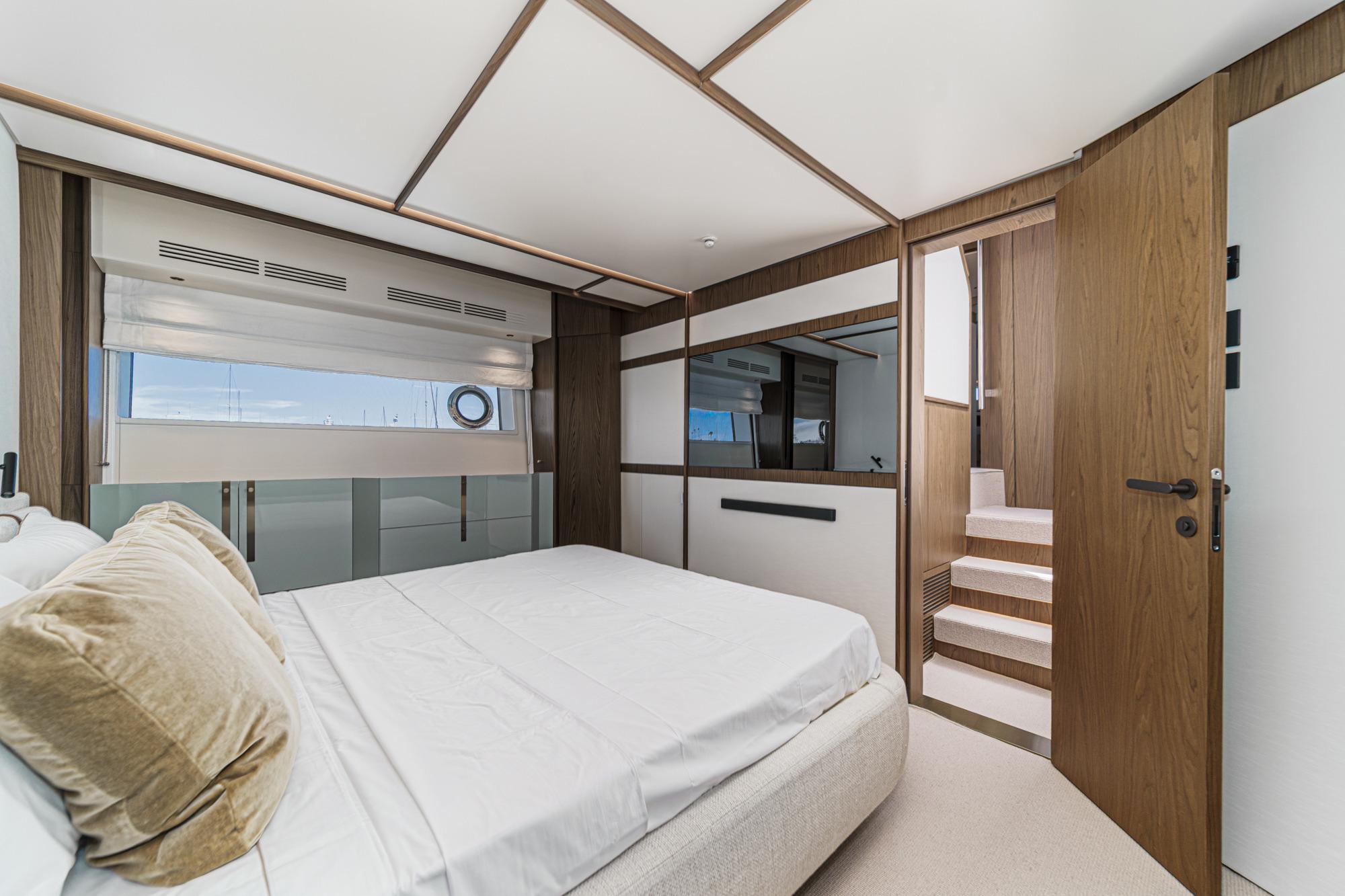 Luxurious bedroom interior of 2026 Azimut Fly 72 yacht with modern design and wooden accents.
