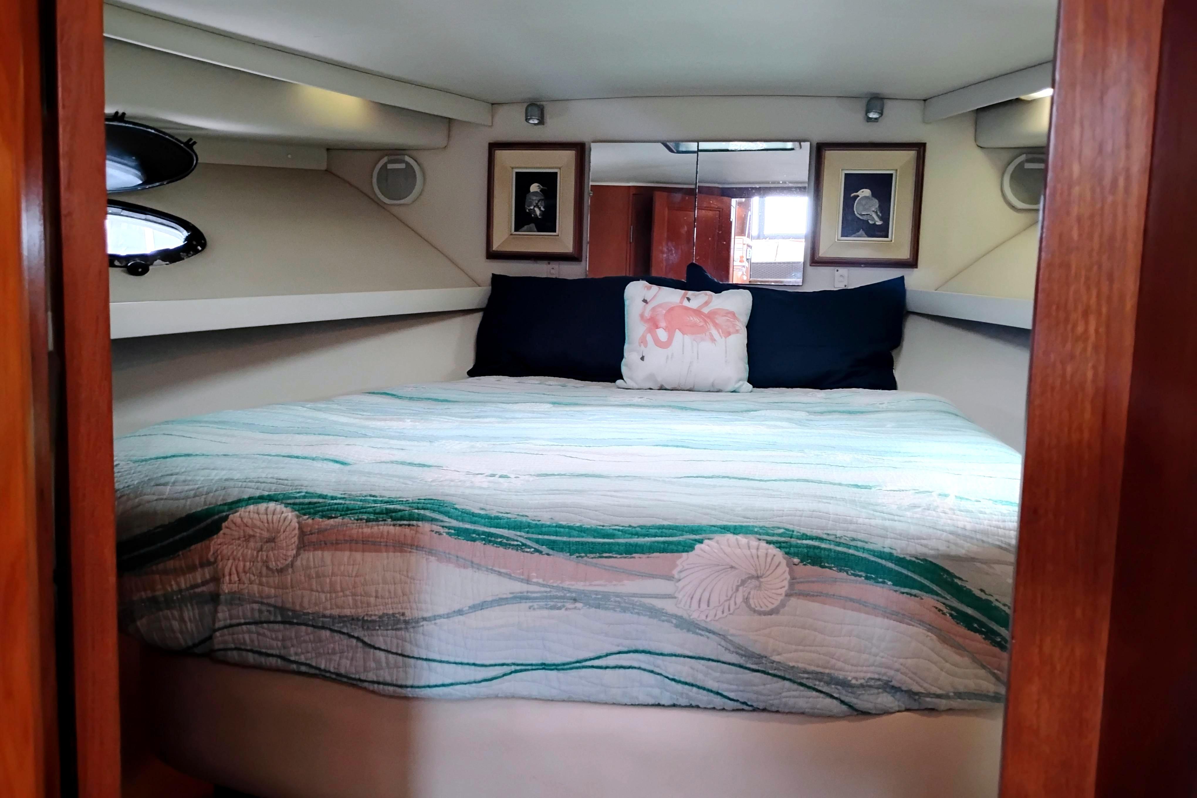 Cozy bedroom in 1991 Californian 52 Cockpit Motor Yacht with nautical decor.