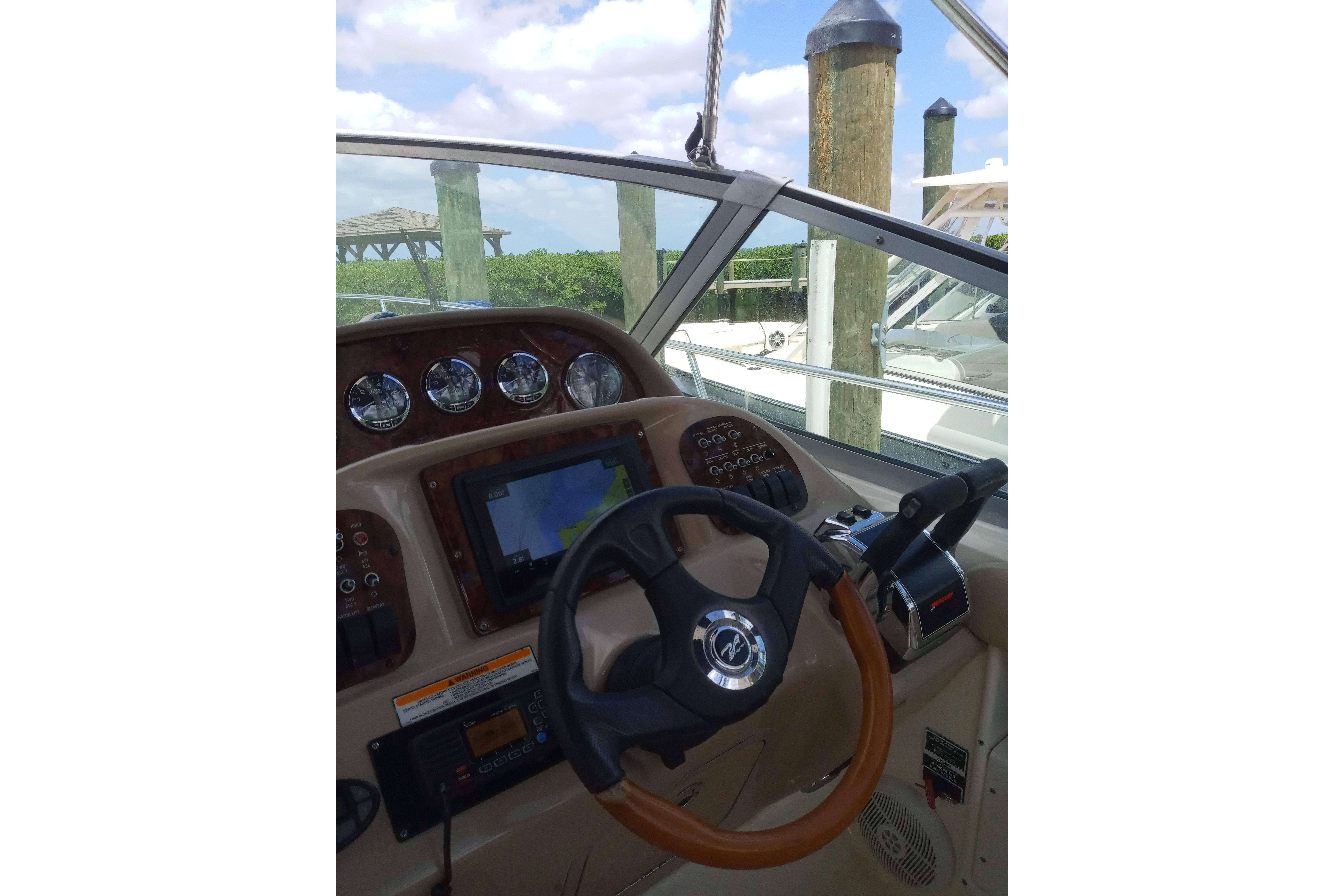 2005 Sea Ray 300 Sundancer helm with steering wheel and navigation controls.