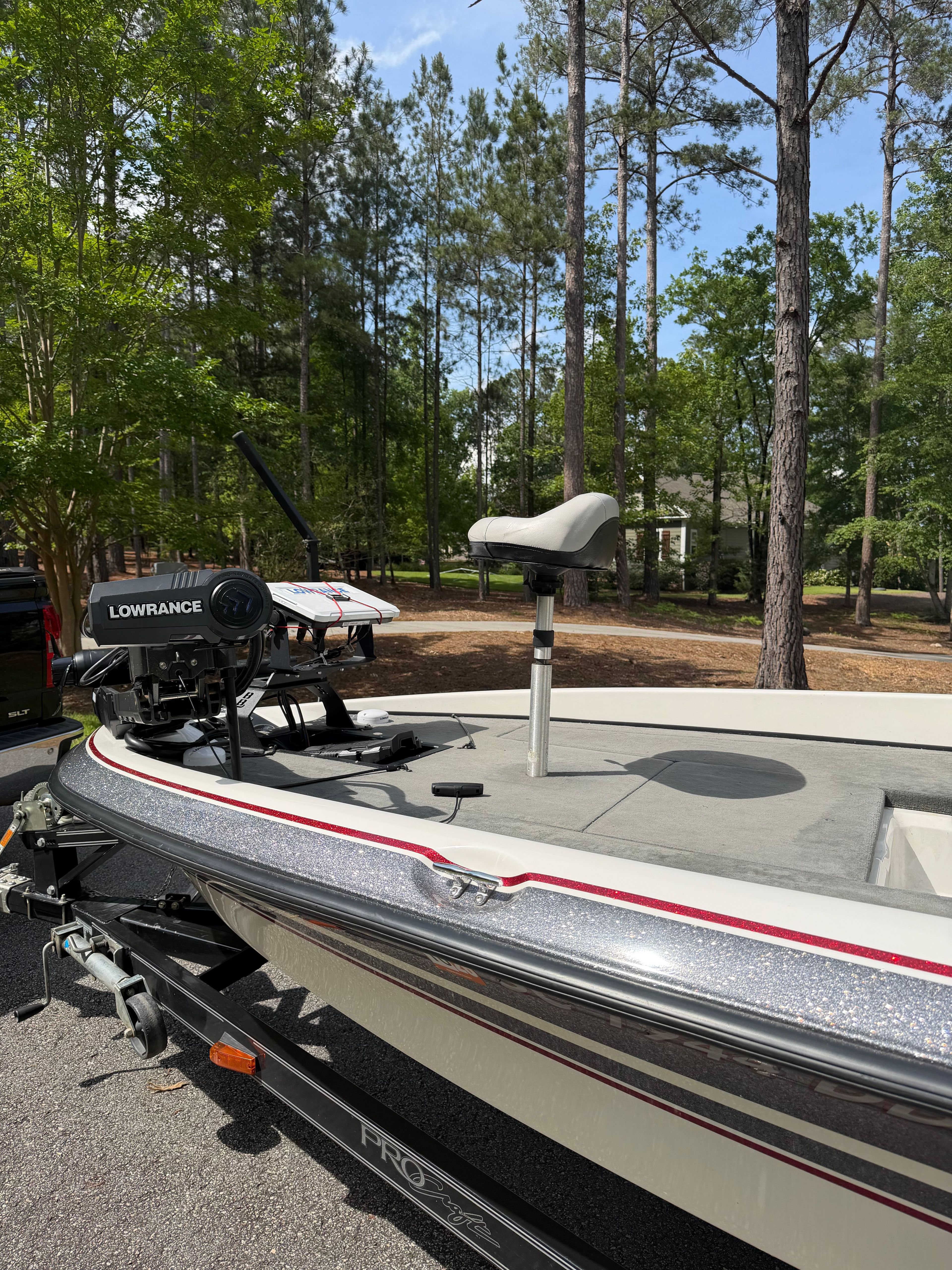 A 2001 ProCraft Pro 185 SC/DC boat with a Lowrance fish finder, parked in a wooded area.
