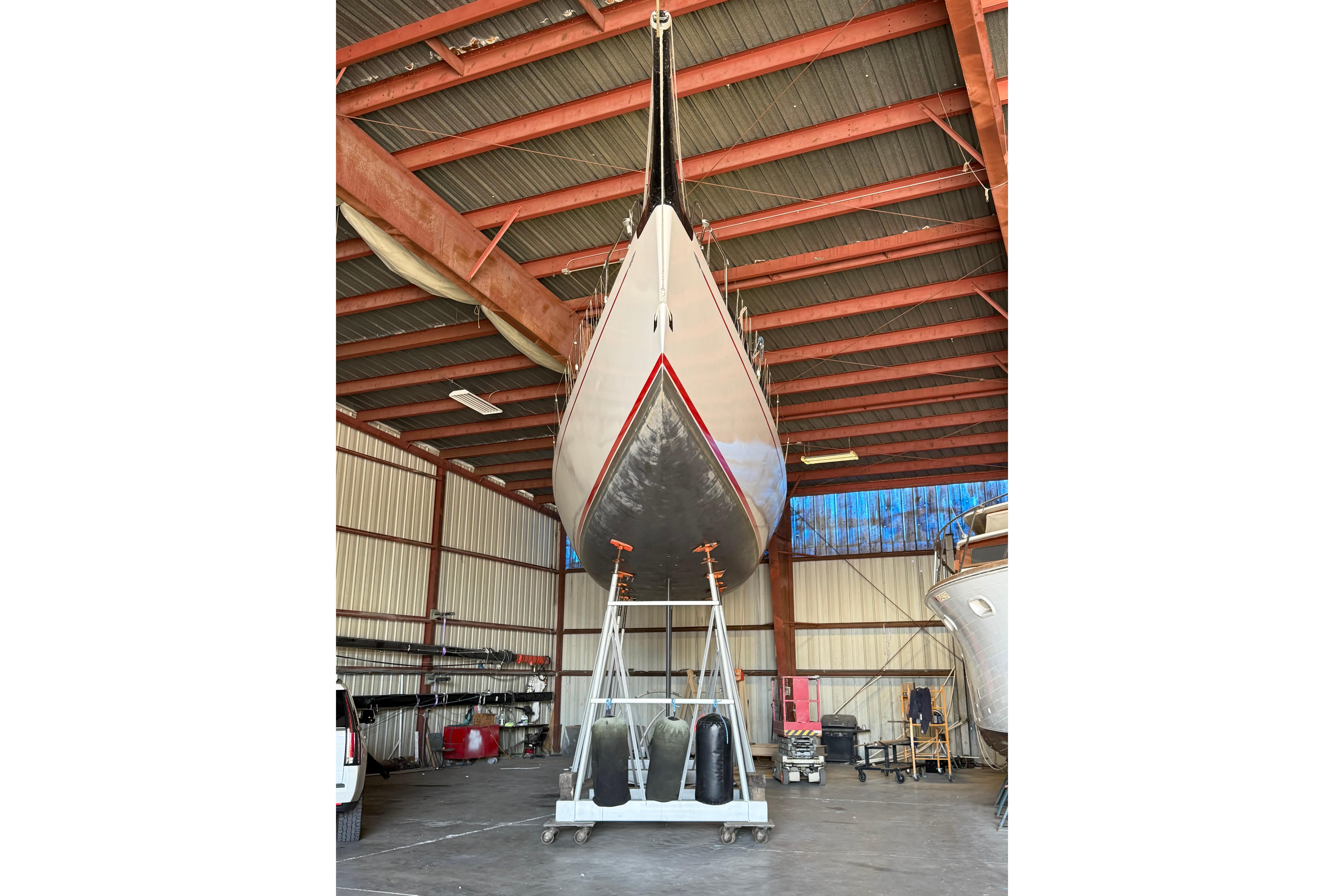 Andrews 63 yacht in a boatyard, elevated for maintenance inside a metal-roofed structure.