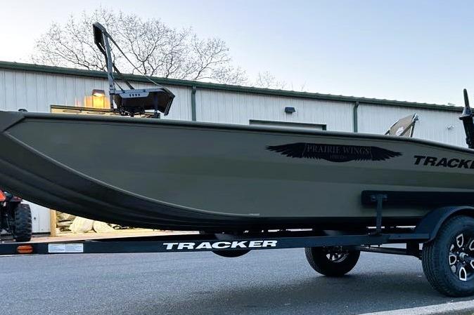 2026 Tracker Grizzly 1650 T Prairie Wings Edition boat on trailer, parked outdoors.
